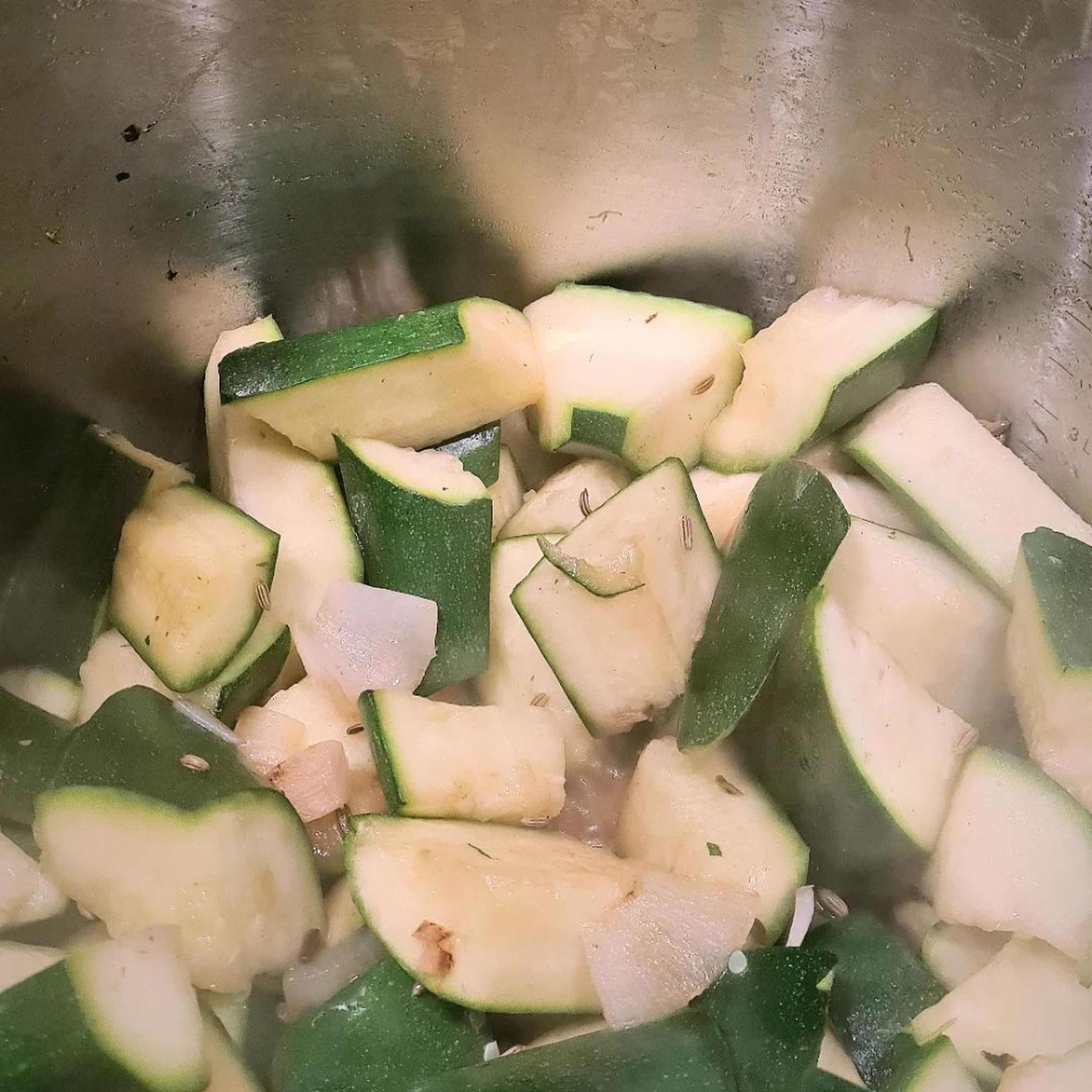 Die Zucchini in grobe Stücke schneiden und mit in den Topf geben. Zugedeckt etwa 10 Minuten auf kleiner Flamme schmoren, bis die Zucchini weich ist. Gelegentlich umrühren, damit nichts anbrennt.