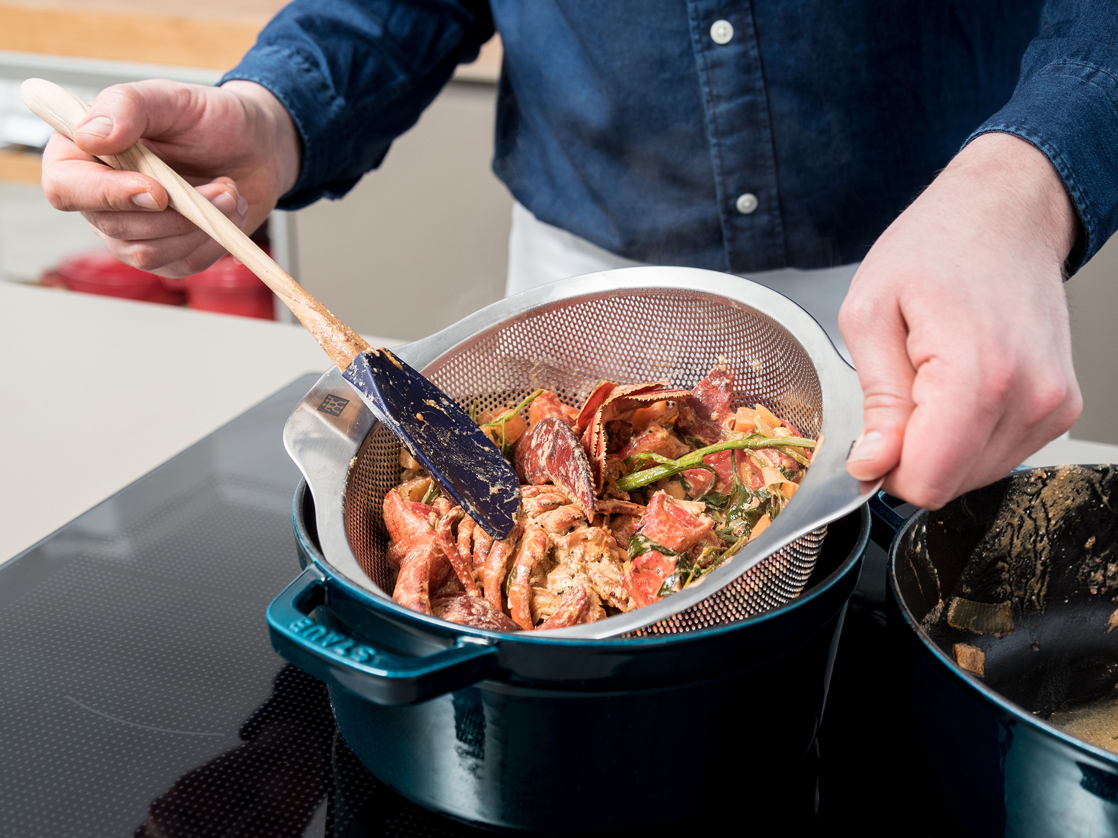 Remove the lobster-vegetable mixture from the heat and strain through a sieve into a clean pot. Remove as much liquid as possible and discard solids. Set pot over low heat and reduce into a thick sauce, whisking occasionally.