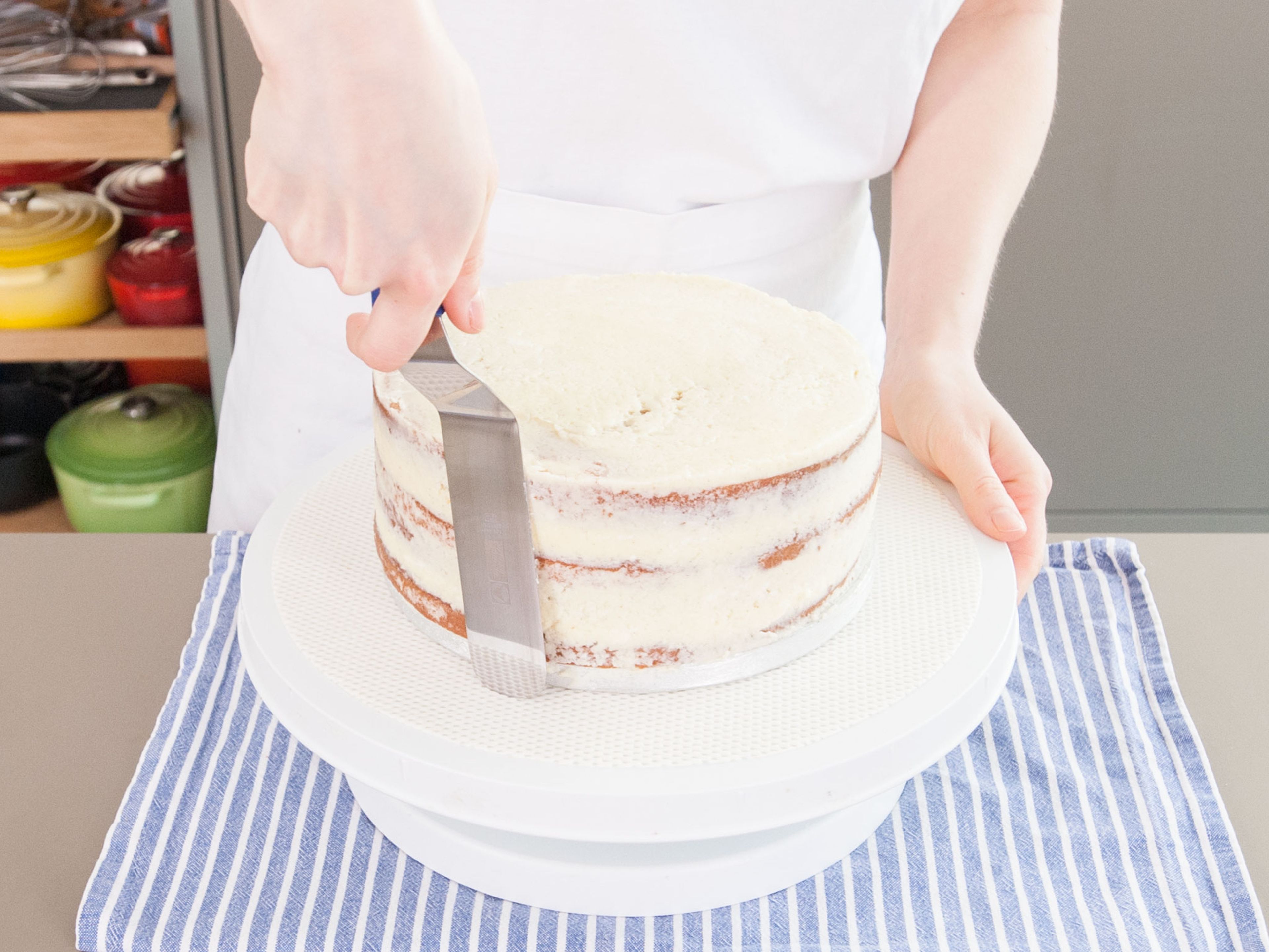 Apply a crumb coat to each tier by spreading a thin layer of buttercream over the tops and sides. Scrape and clean spatula as you go to prevent spreading more crumbs into buttercream. Place tiers in refrigerator for at least 30 minutes to firm up before proceeding.