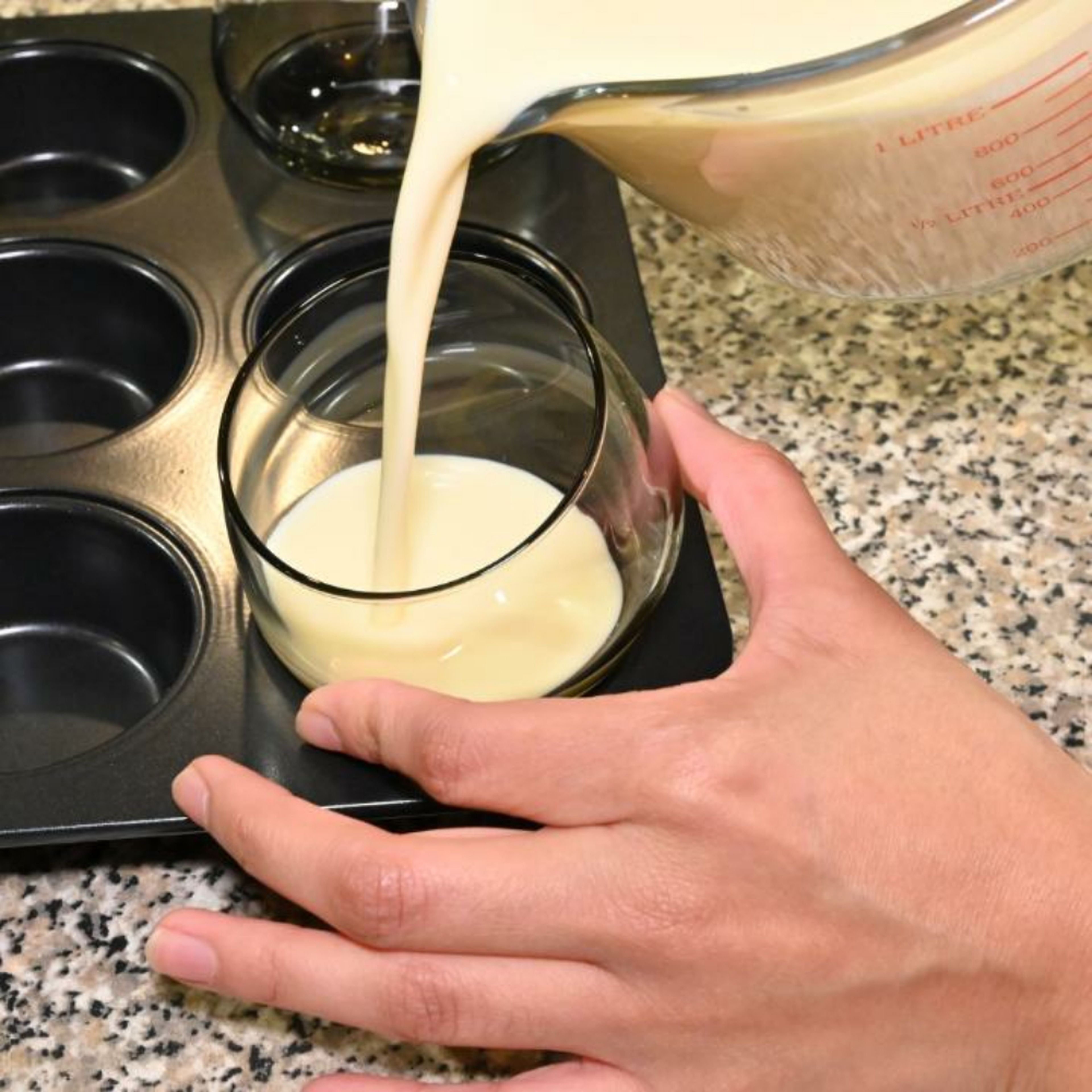 Verwende eine Muffinform, um die Dessertgläser darin zu platzieren. Stelle die Gläser leicht diagonal in die Muffinform und halte sie fest, während du vorsichtig die Crememischung hineingießt. So entsteht die besondere Schichtung.
