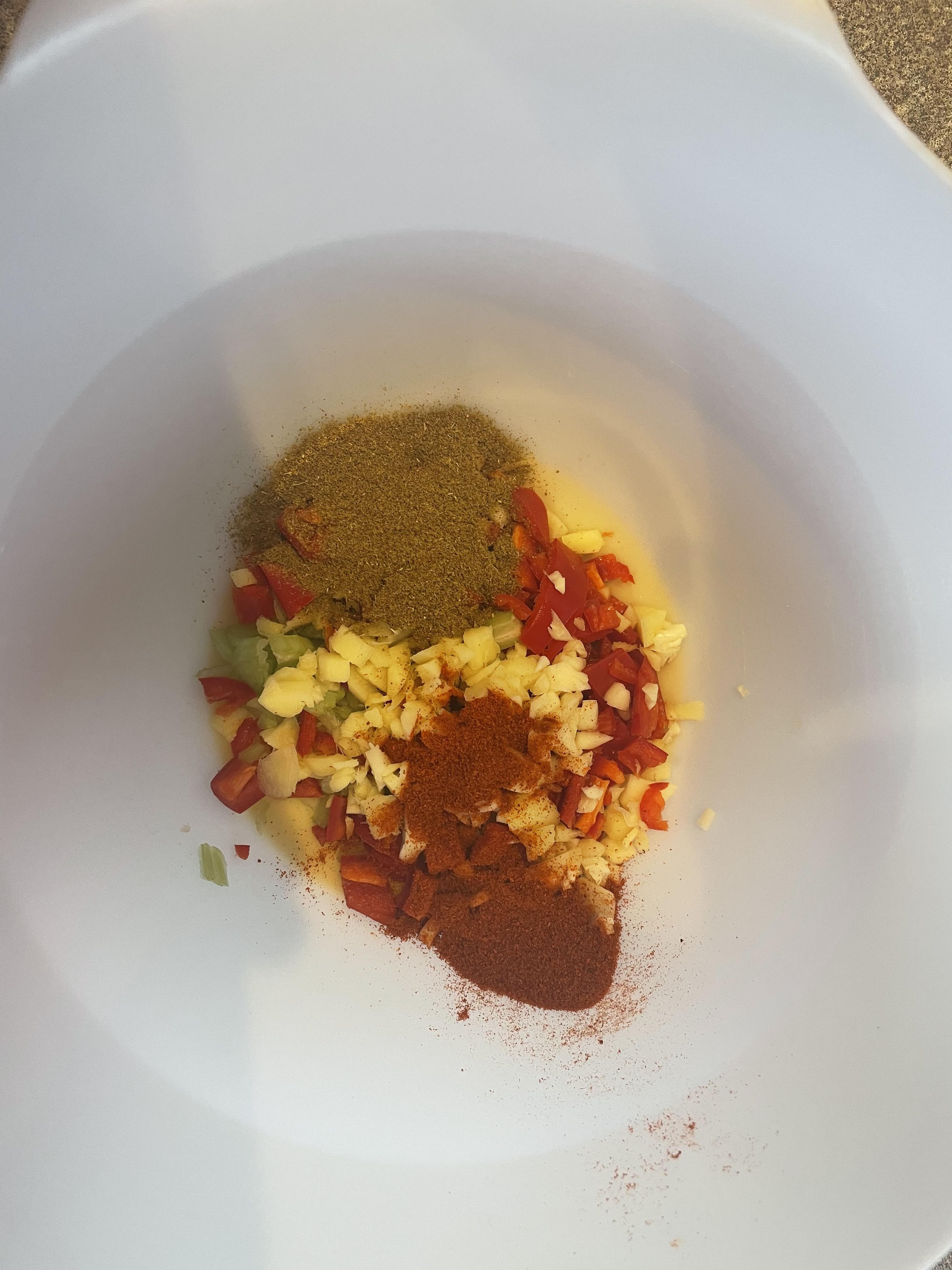 Add the chillies, celery, garlic and ginger into a mixing bowl once in the bowl add your 2tsp of Hot paprika, Cumin Powder and 1 pinch of salt and mix it all together. 