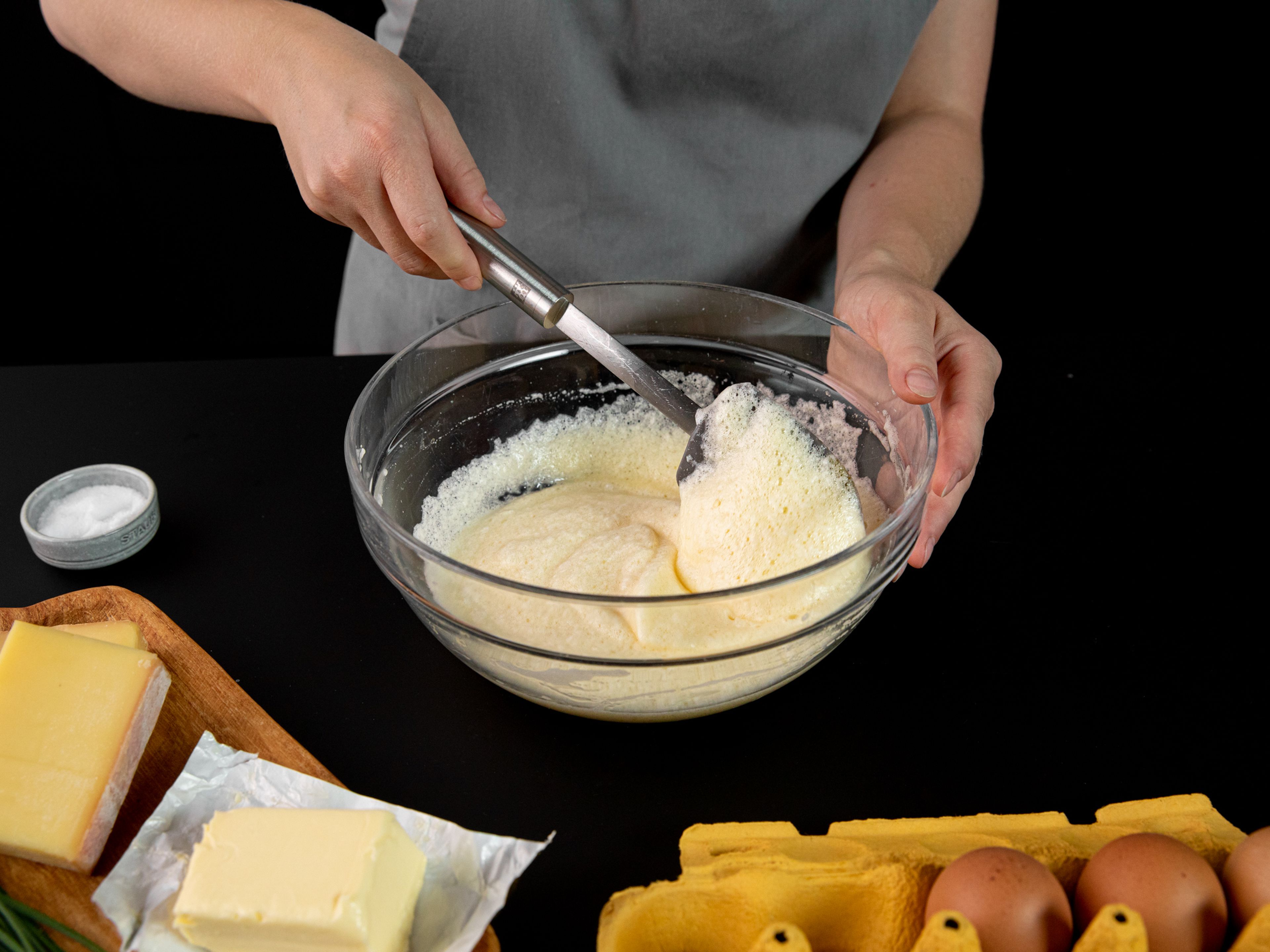 Whisk in half the egg whites to the yolks, then fold in remaining egg whites with a rubber spatula.