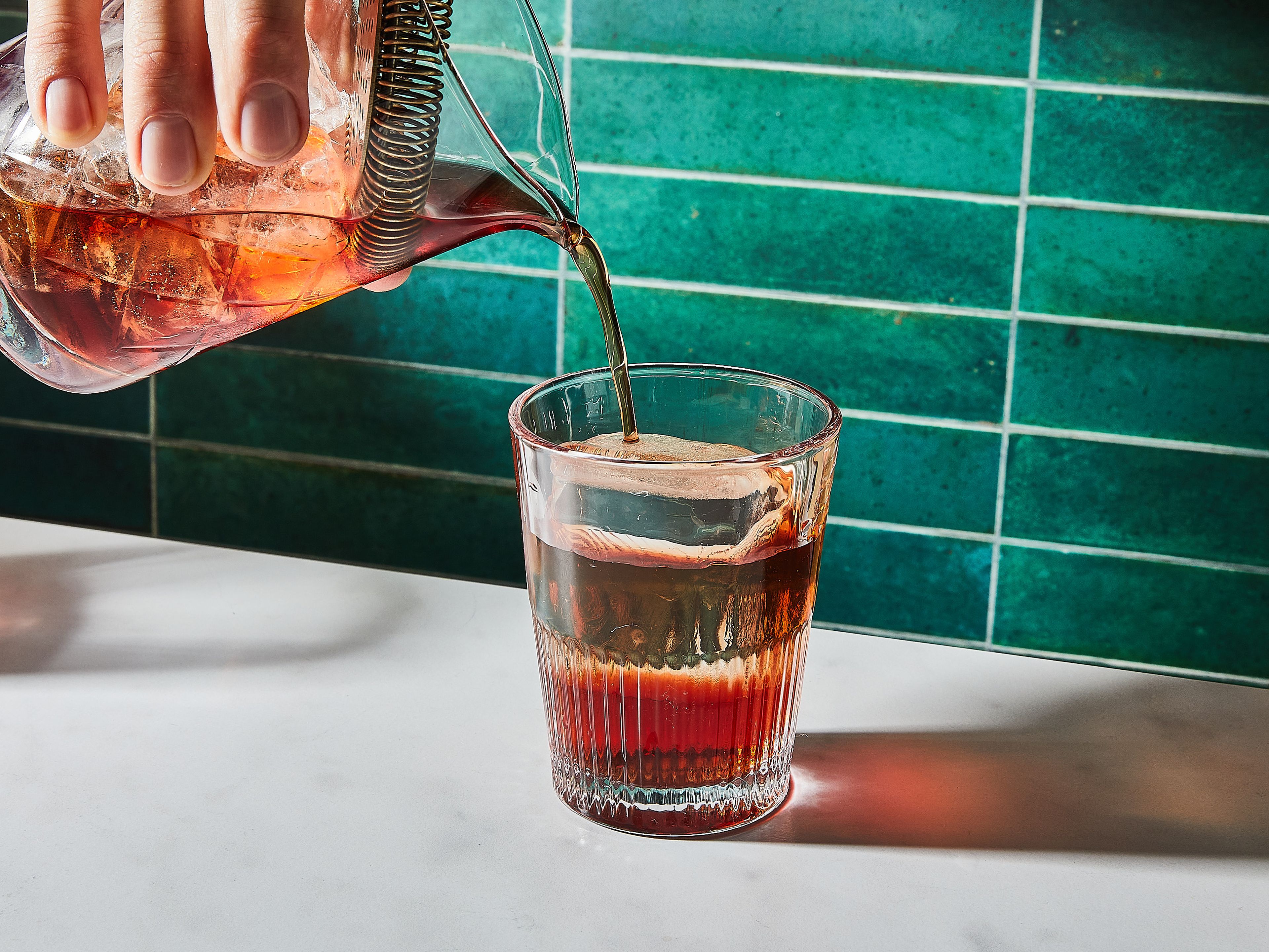 Nur den Drink, ohne die Eiswürfel und eventuell mithilfe eines Cocktailsiebs, in ein Glas mit einem großen Eiswürfel darin füllen. Du kannst einfachheitshalber auch die kleinen Eiswürfel aus dem ersten Schritt verwenden.