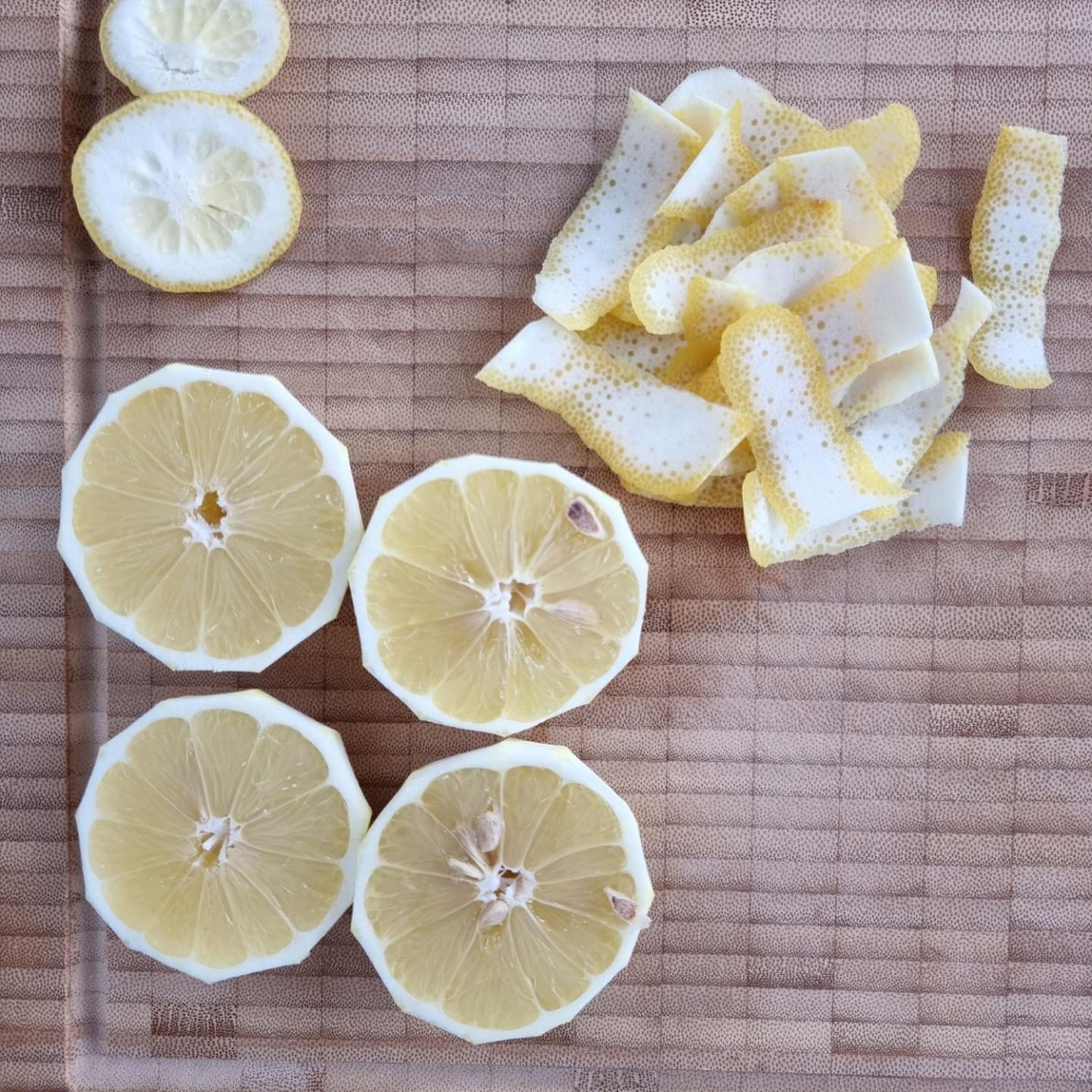 Von zwei Zitronen die Schale abschneiden und den Parmesan fein reiben.