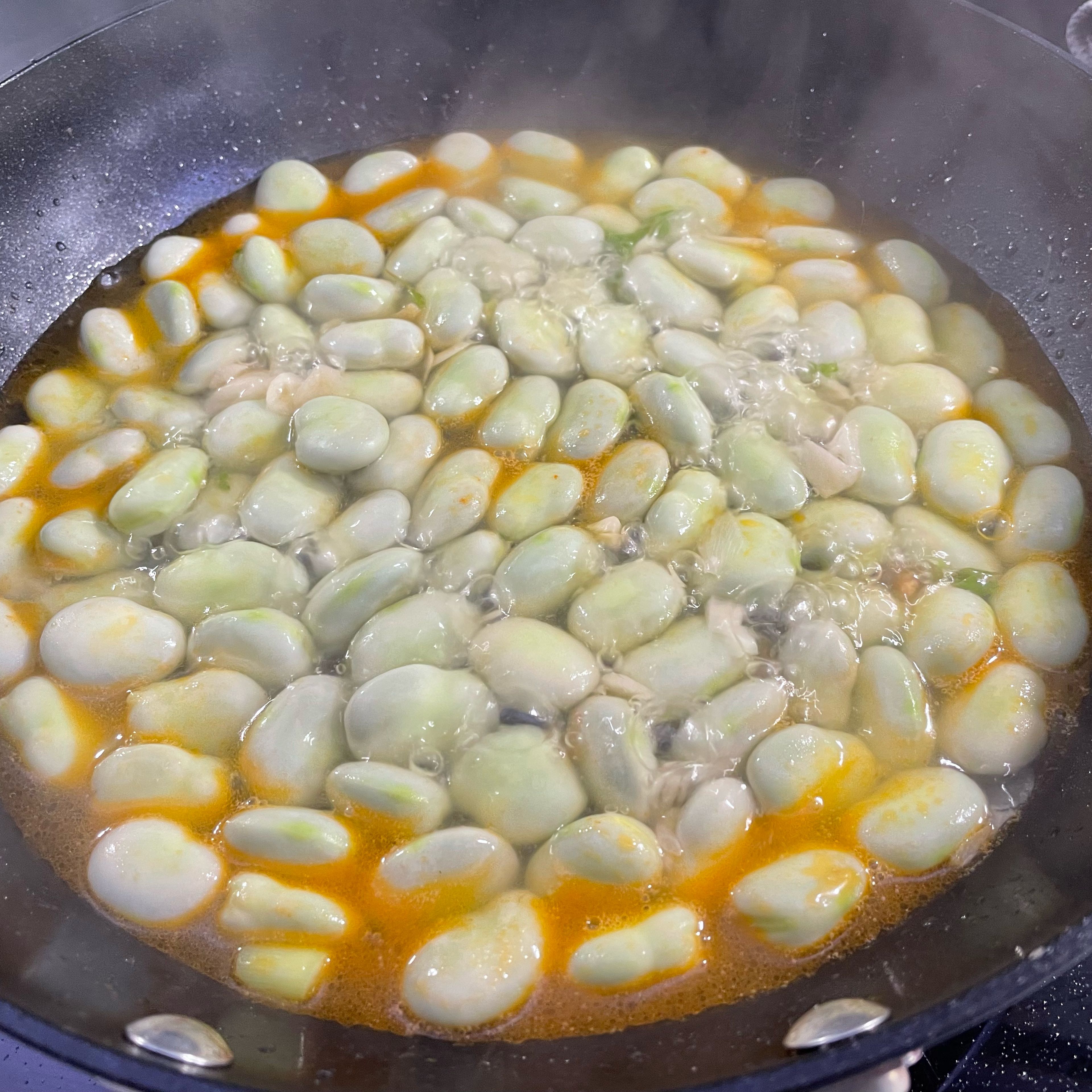 Add oil into pan, stir fry the garlic and spring onion first, then add beans. Fry for 5 mins then add boiled water to cover the beans. Cook for 20 mins