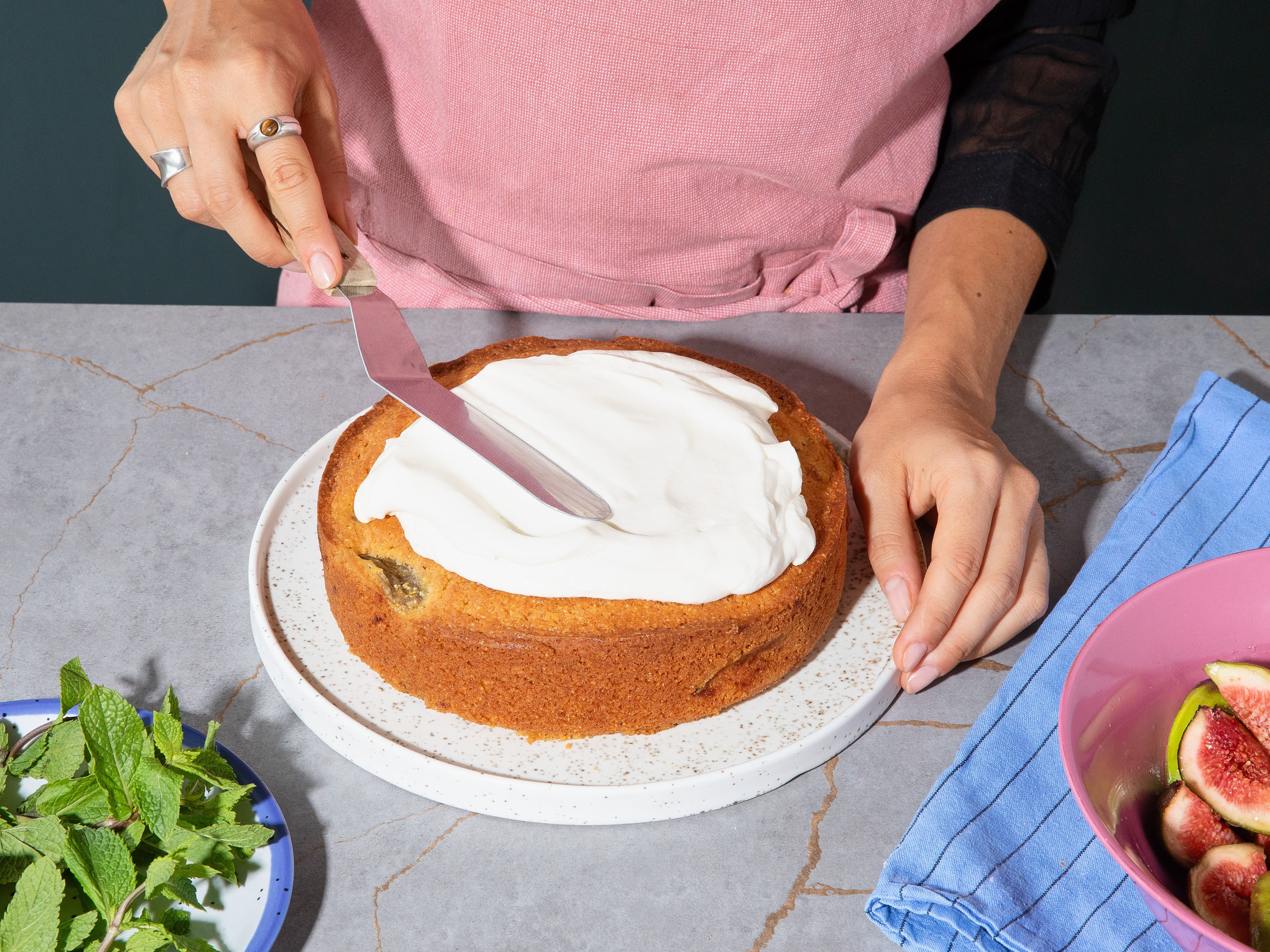 Let the cake cool completely. Top with the yogurt cream, then spoon over the remaining marinated figs. Garnish with fresh mint and serve immediately.