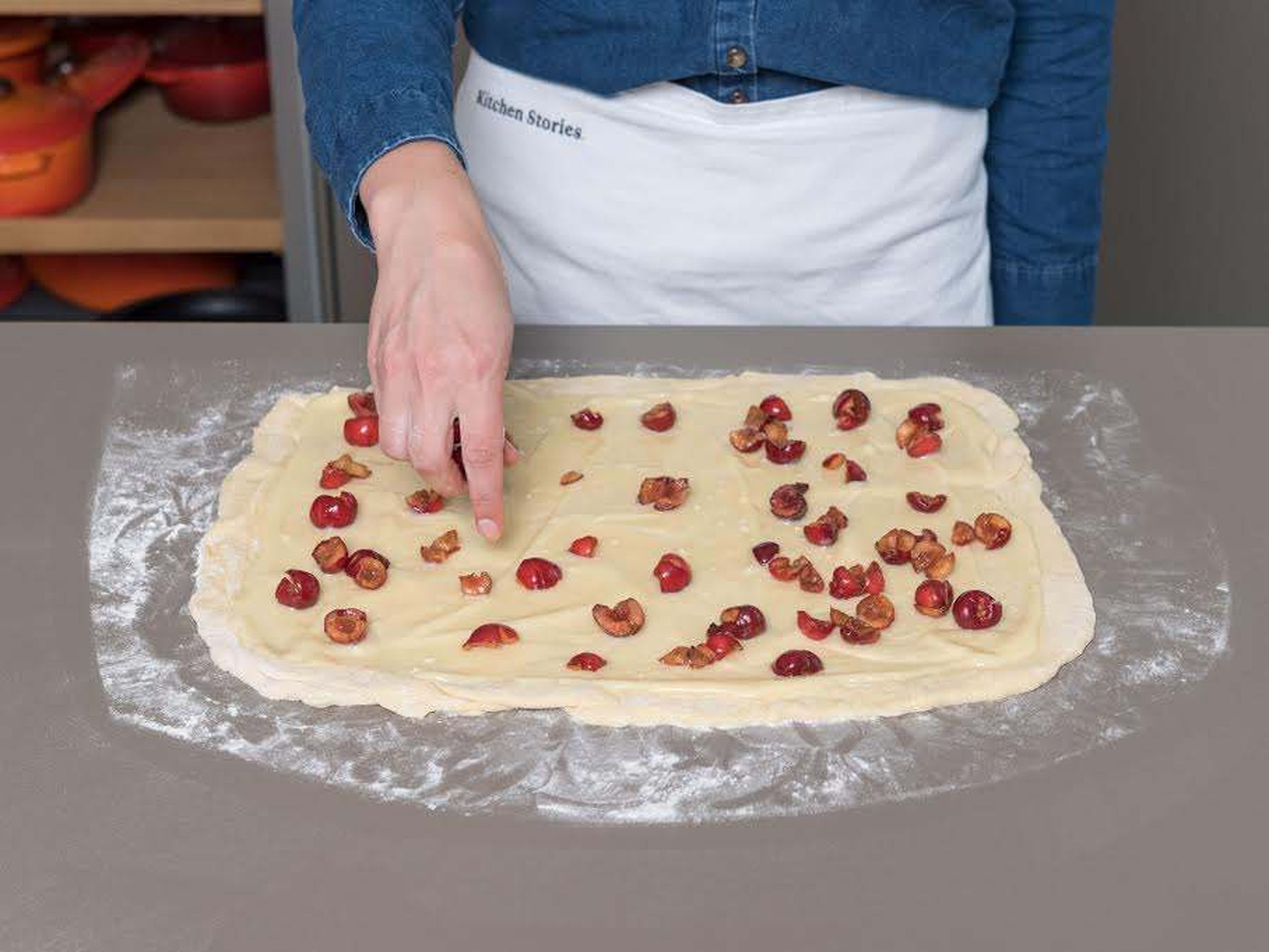 Roll out the dough on a floured surface to a rectangle of approx. 30 x 45 cm/12 x 18 in. Spread white chocolate and cream cheese mixture onto the dough, leaving a small border all around, and distribute cherries evenly on top. Then, starting at the long end, roll up the dough and cut log into 12 equally sized pieces with a sharp knife. Place the rolls in a greased baking dish, cover, and leave to rise for approx. 30 - 45 min. Preheat oven to 175°C/350°F.