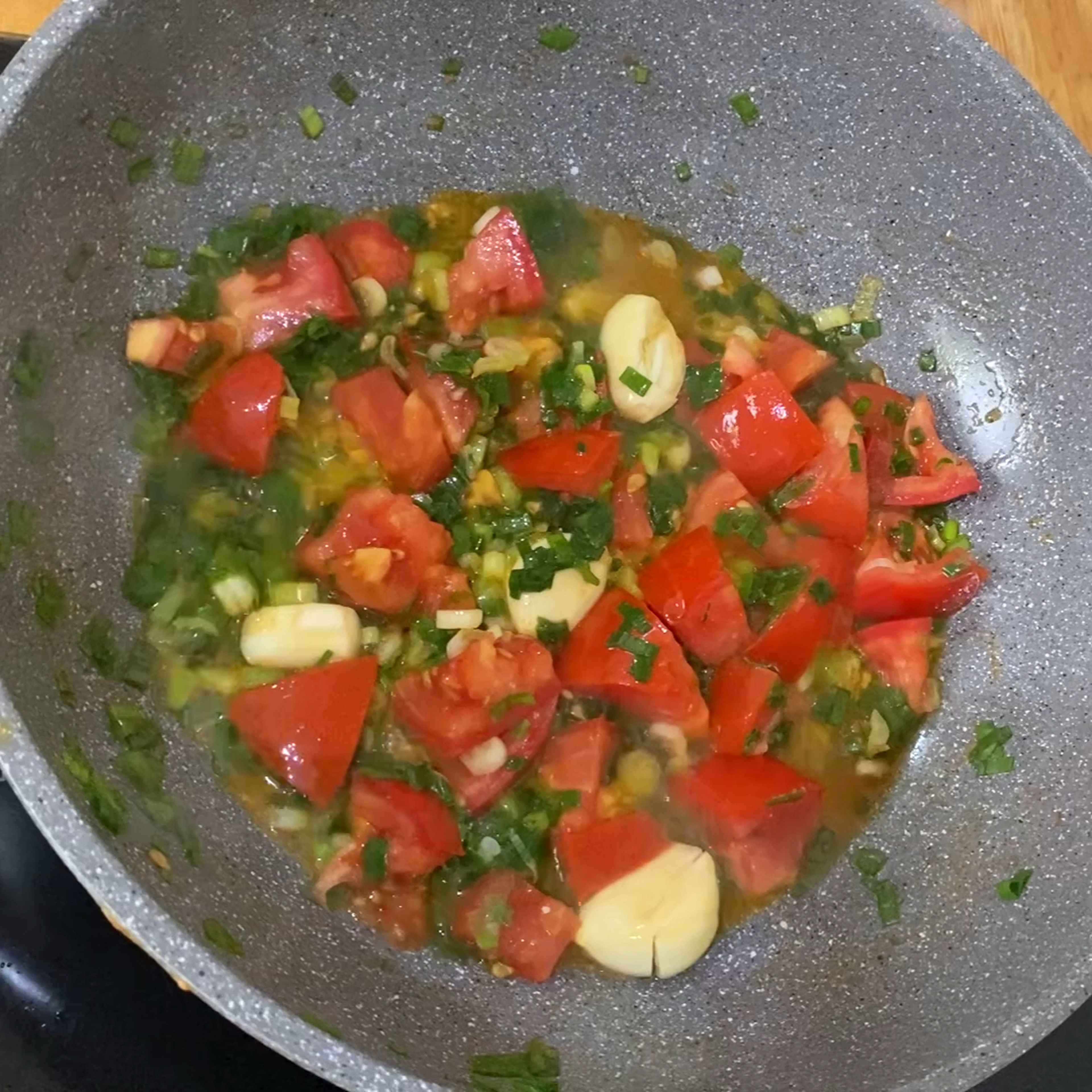 Add more oil to the pan, insert green onions, tomatoes, and garlic. Cook until soft.