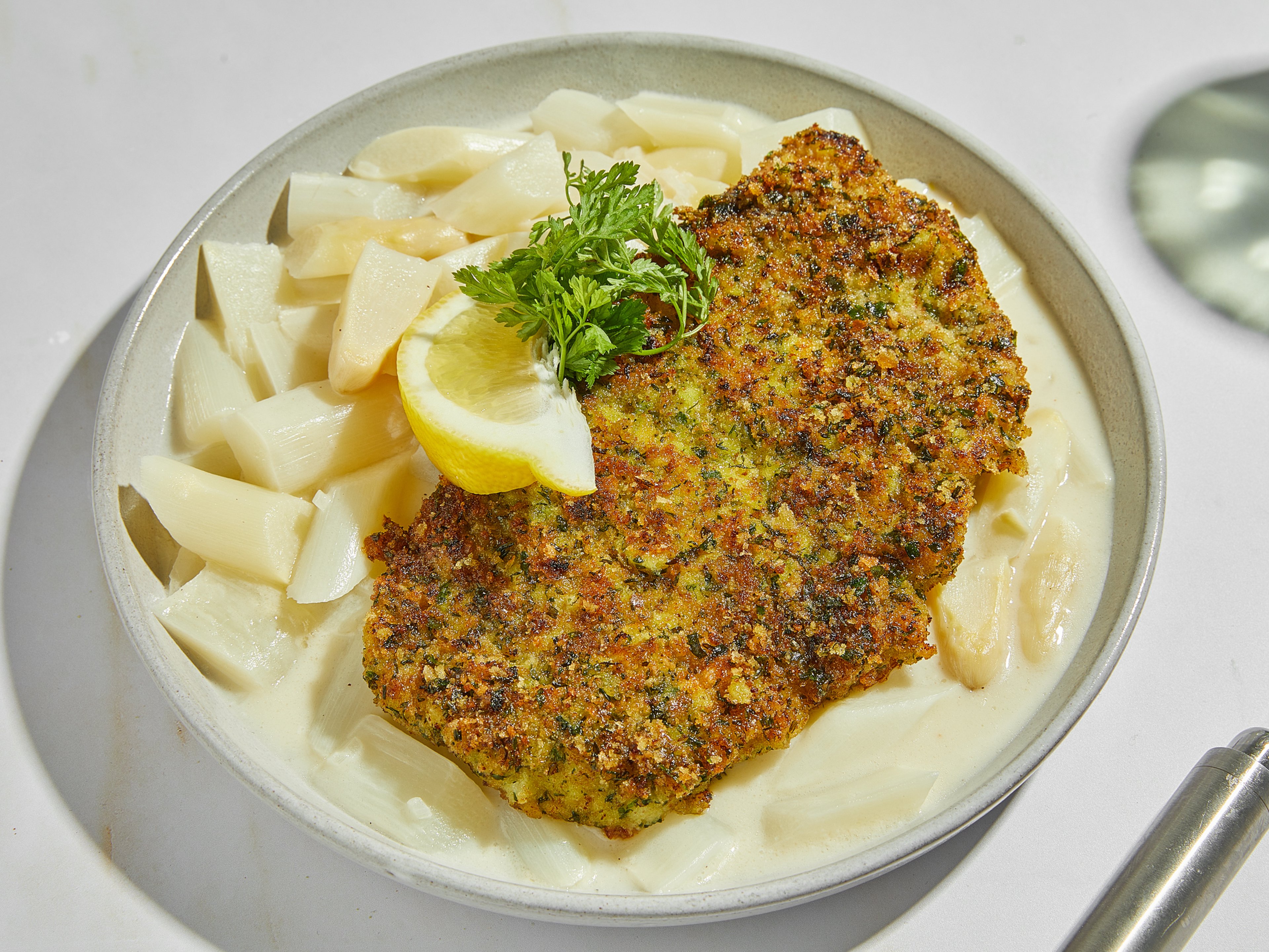 Herby schnitzel with simple white asparagus ragu