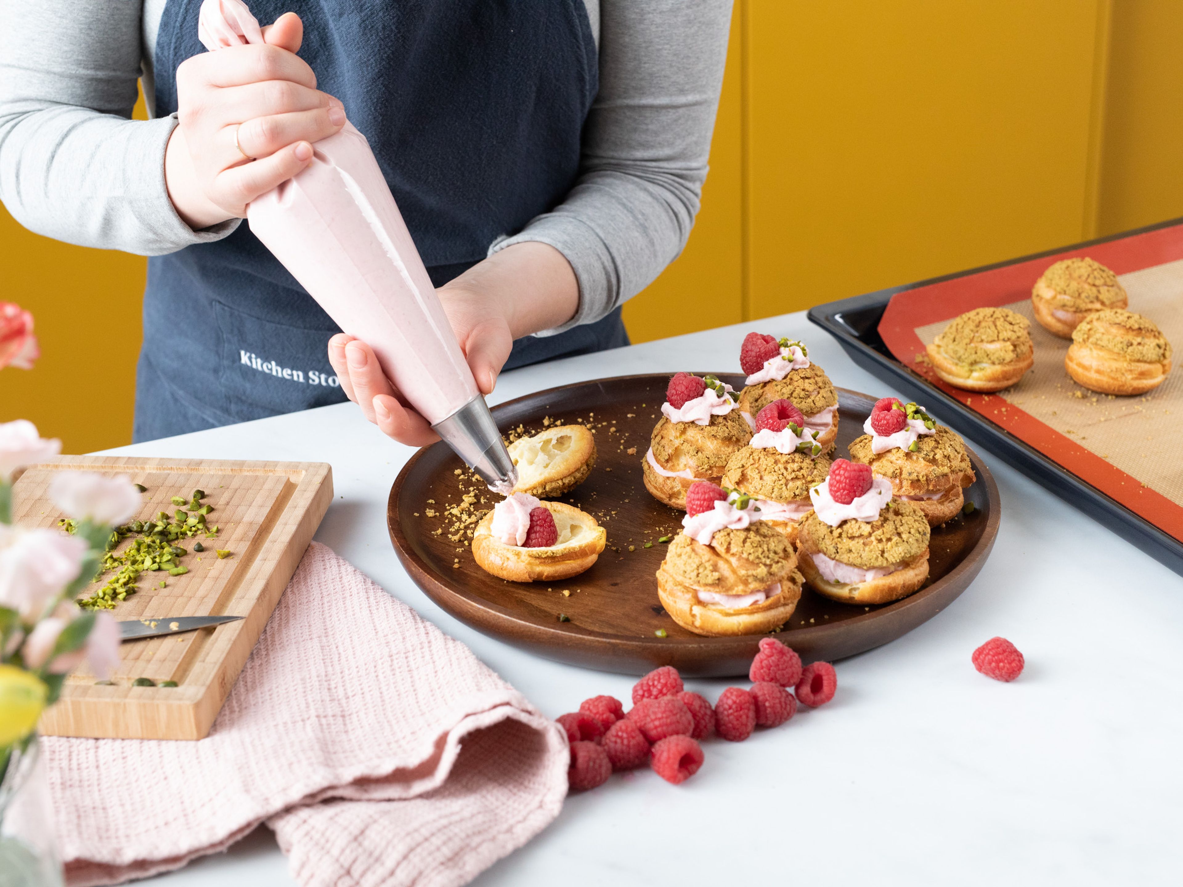 To assemble, carefully halve the cream puffs and fill each pair with raspberry cream and fresh raspberries. Decorate with extra pistachios, raspberries, and confectioner’s sugar. Enjoy!