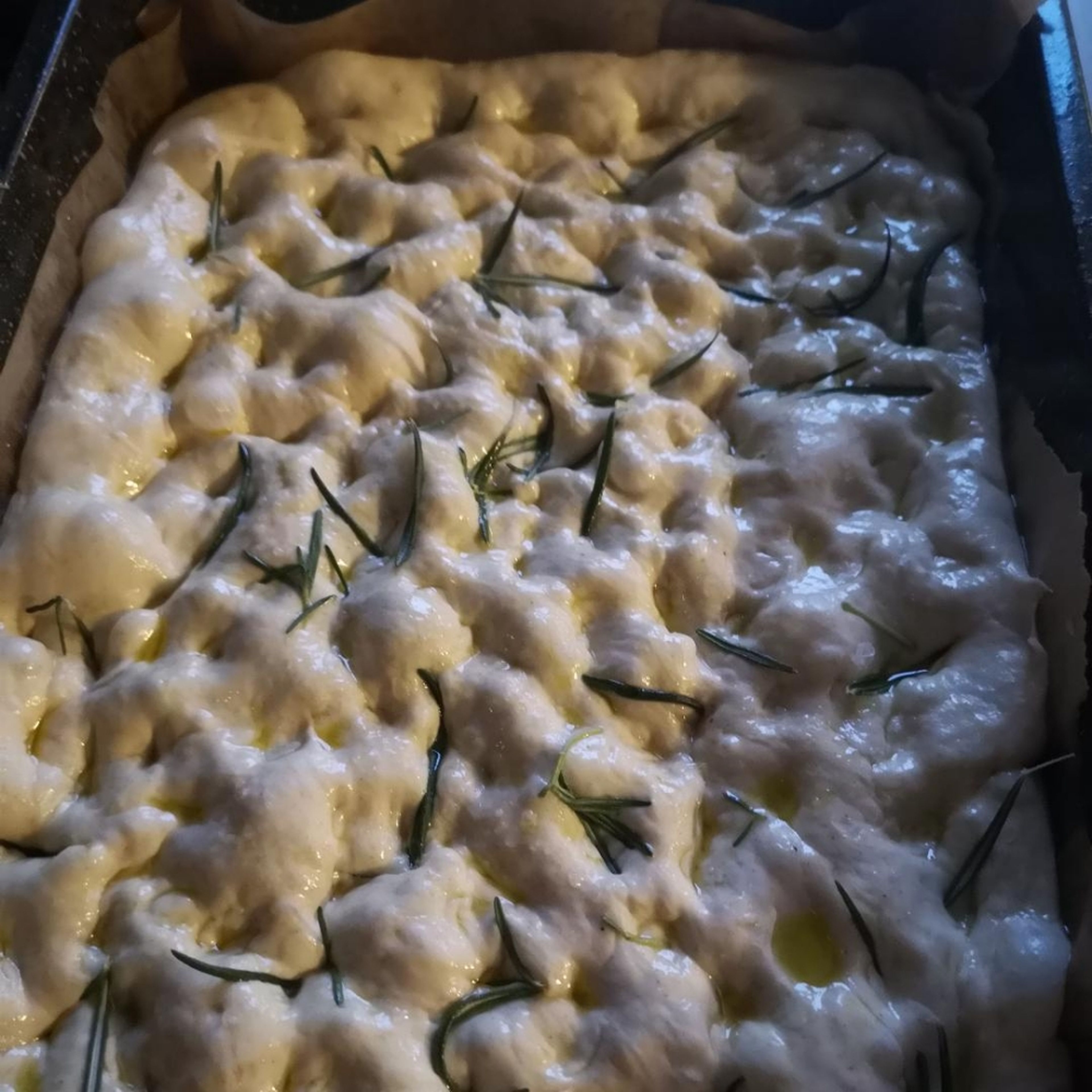 after 30 minimum of rest, the dough should have risen a little more, once more using your fingertips create craters in the surface of the dough, drizzle over the remaining olive oil, sprinkle the fresh rosemary and salt as desired. (If you have access to Maldon salt, this is a recipe for it to shine!)
