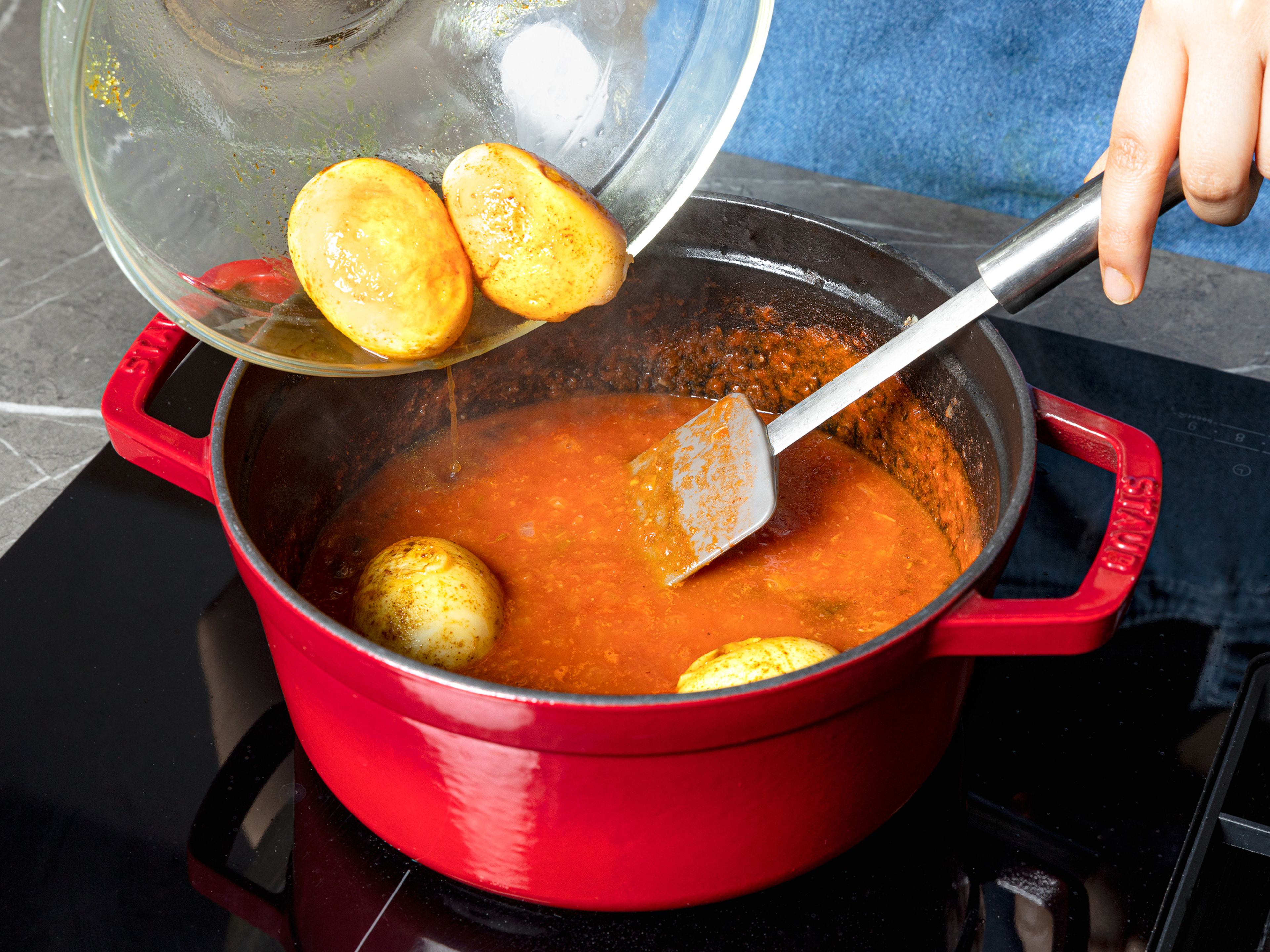 Mit stückigen Tomaten und Wasser ablöschen. Leicht köcheln lassen und bei mittlerer Hitze ca. 12–15 Min. einkochen lassen. Falls das Curry zu trocken ist, mehr Wasser hinzufügen. Garam Masala und den größten Teil der Eier in das Curry geben, darauf achten, dass sie bedeckt sind und weitere 2–3 Min. kochen. Wenn das Curry fertig ist, zwei restliche Eier halbieren und das Curry mit diesen und Koriander garnieren. Mit gekochtem Basmatireis servieren.