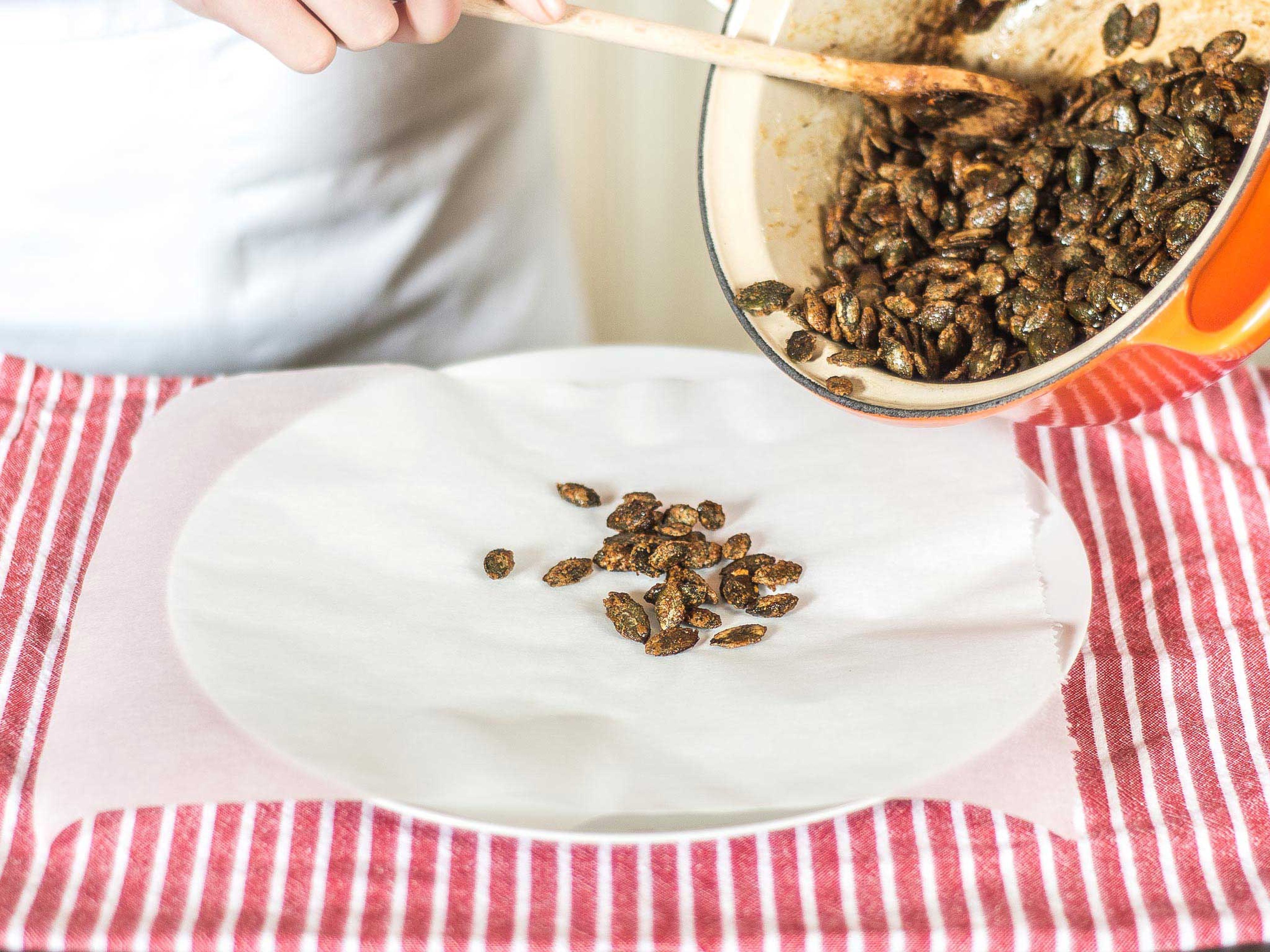 Place the candied pumpkin seeds on a sheet of parchment paper to cool.