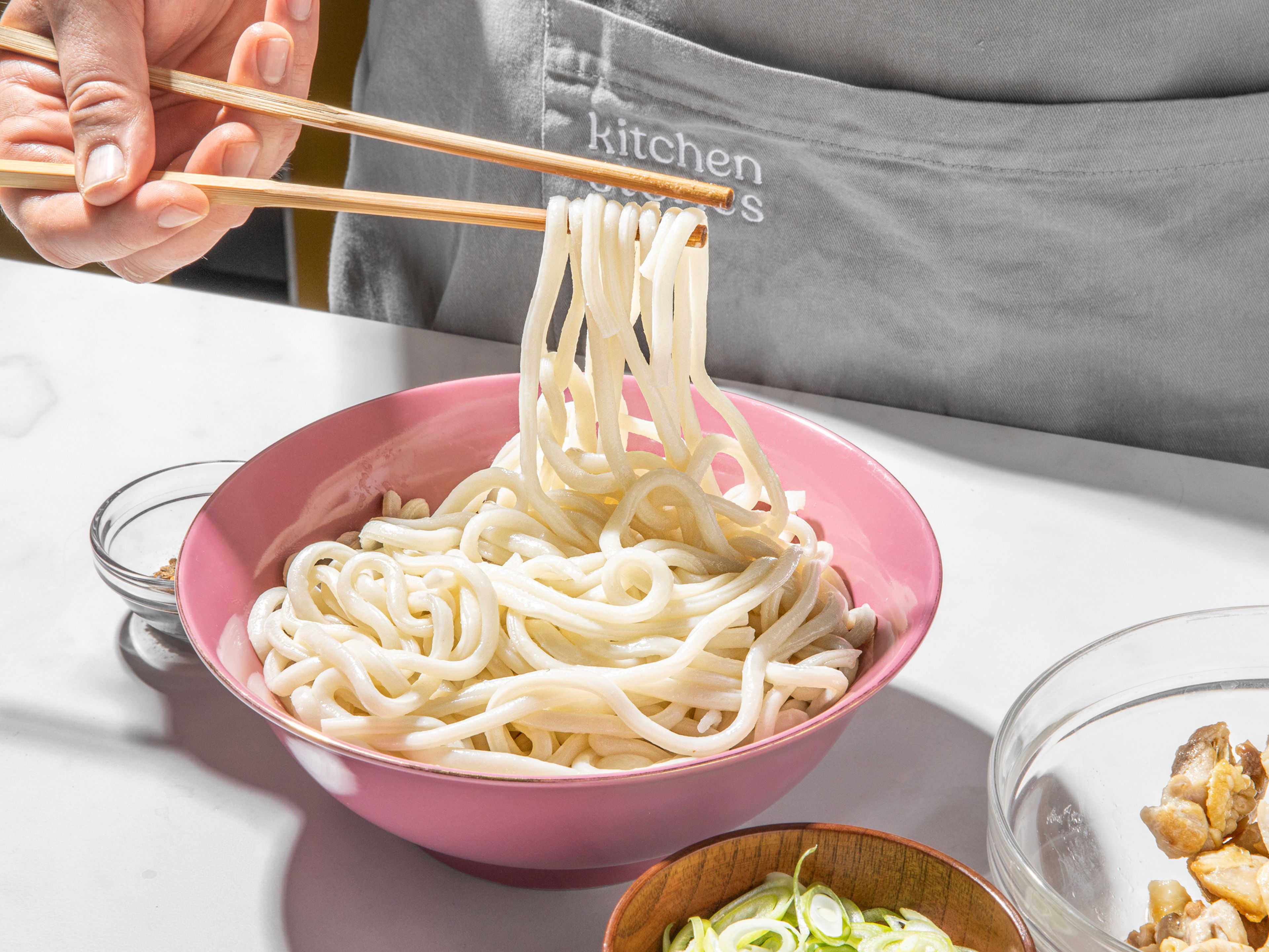 Cook udon noodles according to package instructions and drain. Equally divide noodles and chicken into two bowls and cover with soup. Garnish with scallions and shichimi togarashi or a jammy egg, if desired. Enjoy!