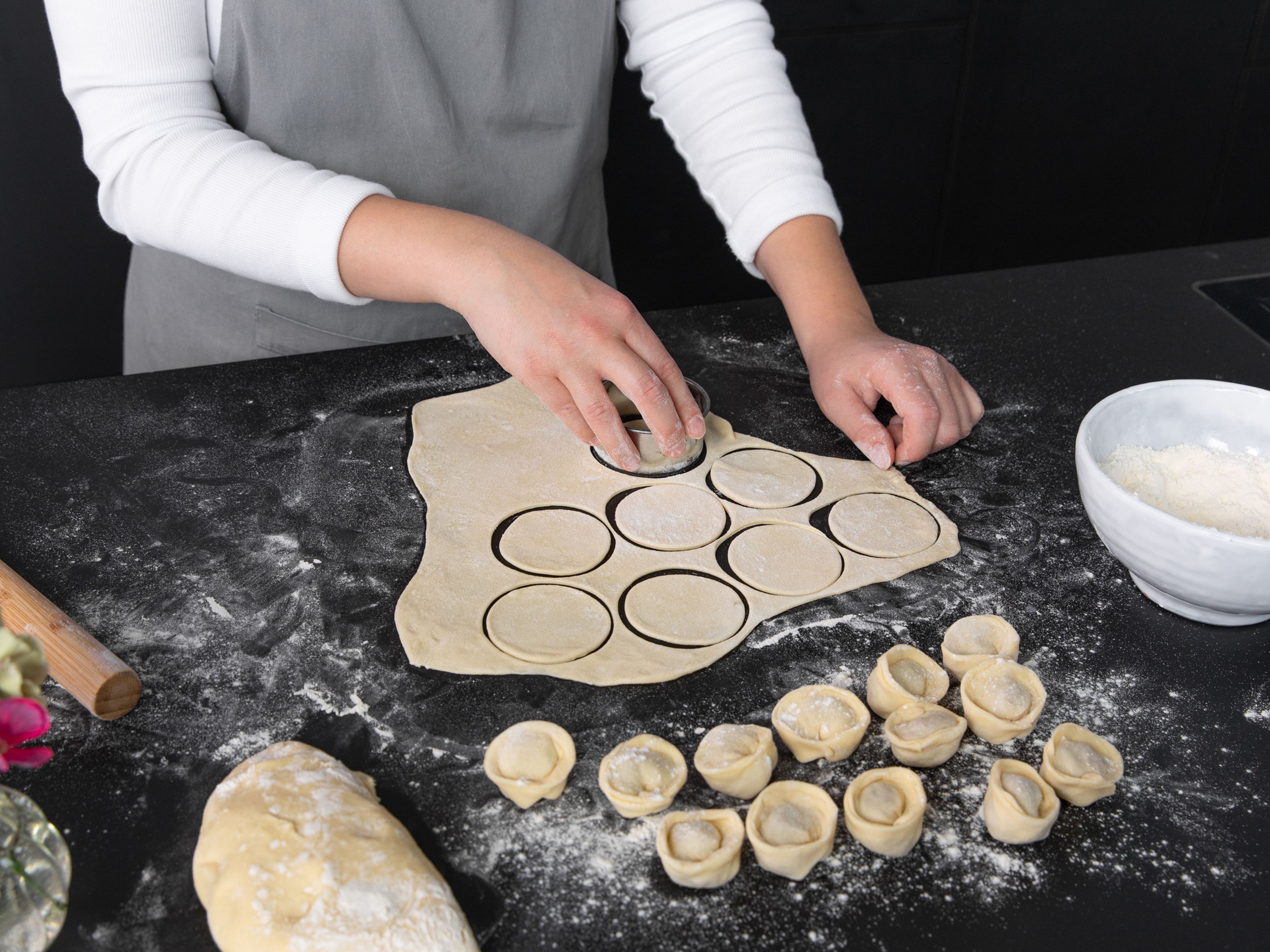 Transfer rested dough to a floured work surface. Divide the dough into four pieces and roll out each with a rolling pin on a floured work surface.