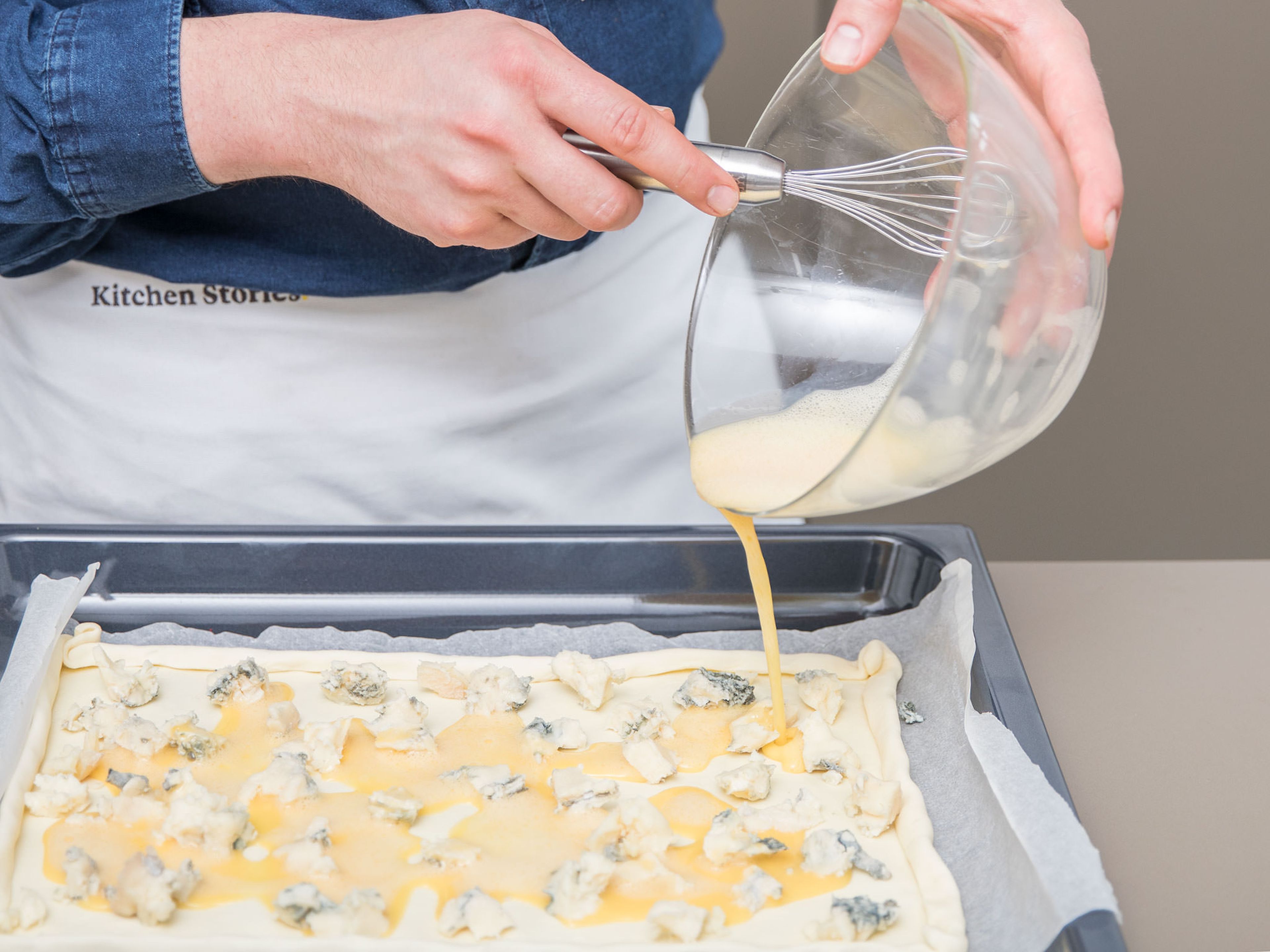 Preheat the oven to 180°C/360°F. Roll out puff pastry on a baking sheet lined with parchment paper. Fold the edges over to create a rim. Spread a thin layer of Gorgonzola cheese on top. Beat the eggs and spread them over the cheese.