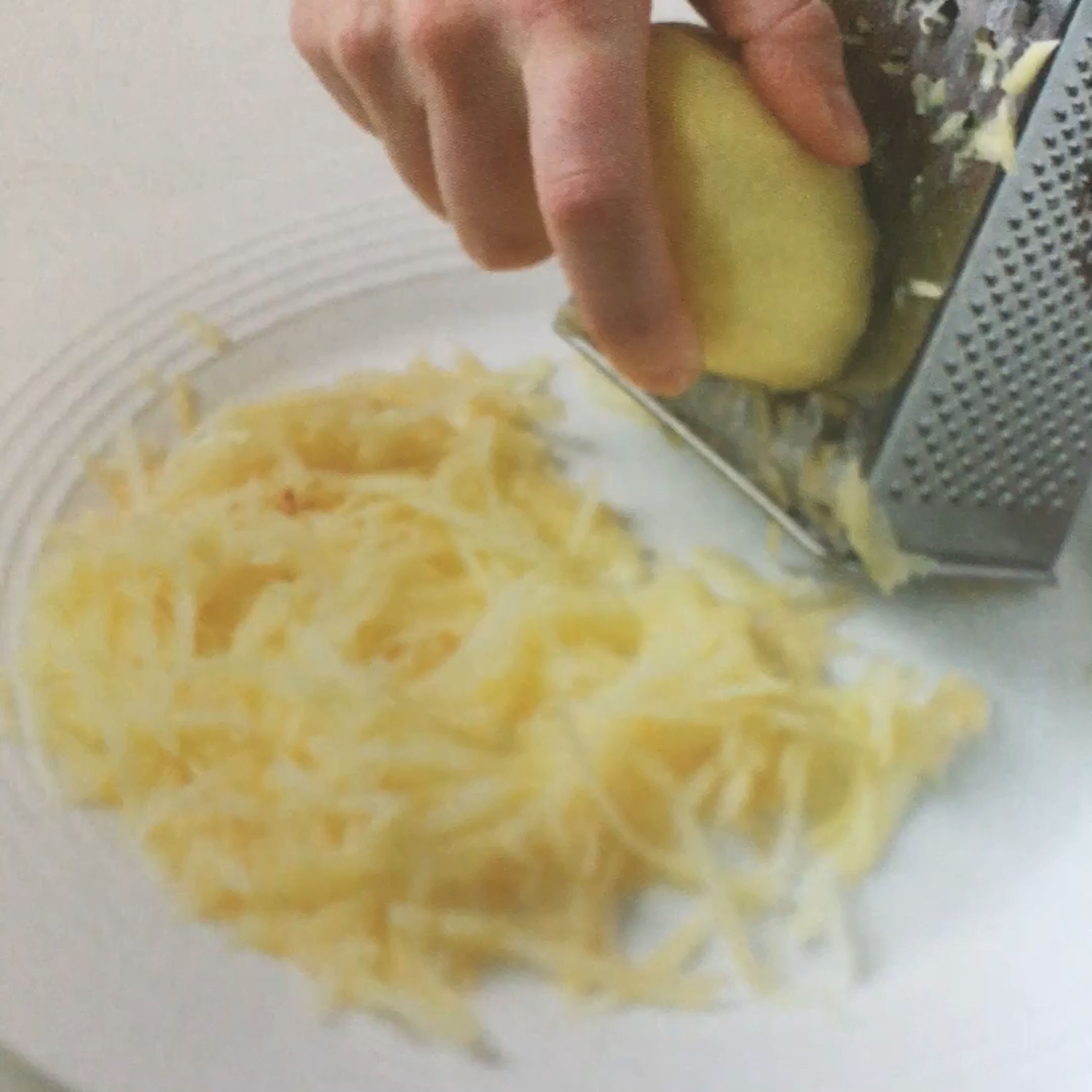 Carefully coarsely great the potatoes into a bowl or onto a plate. Transfer the potatoes on to a clean towel