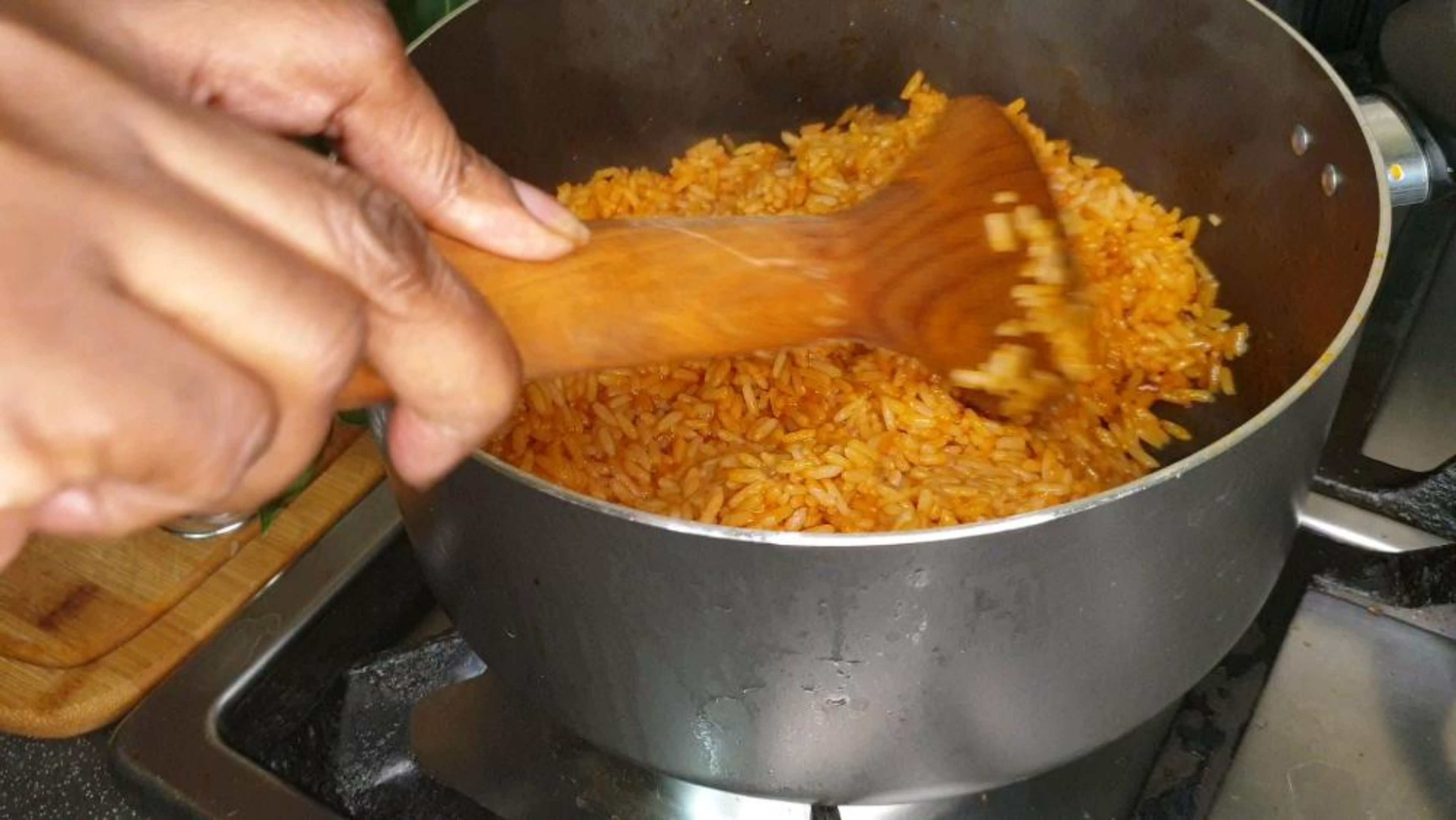 After 20 minutes, gently lift the lid and stir your magnificent creation turning your Jollof rice from the bottom of the pot but do this extremely gently.