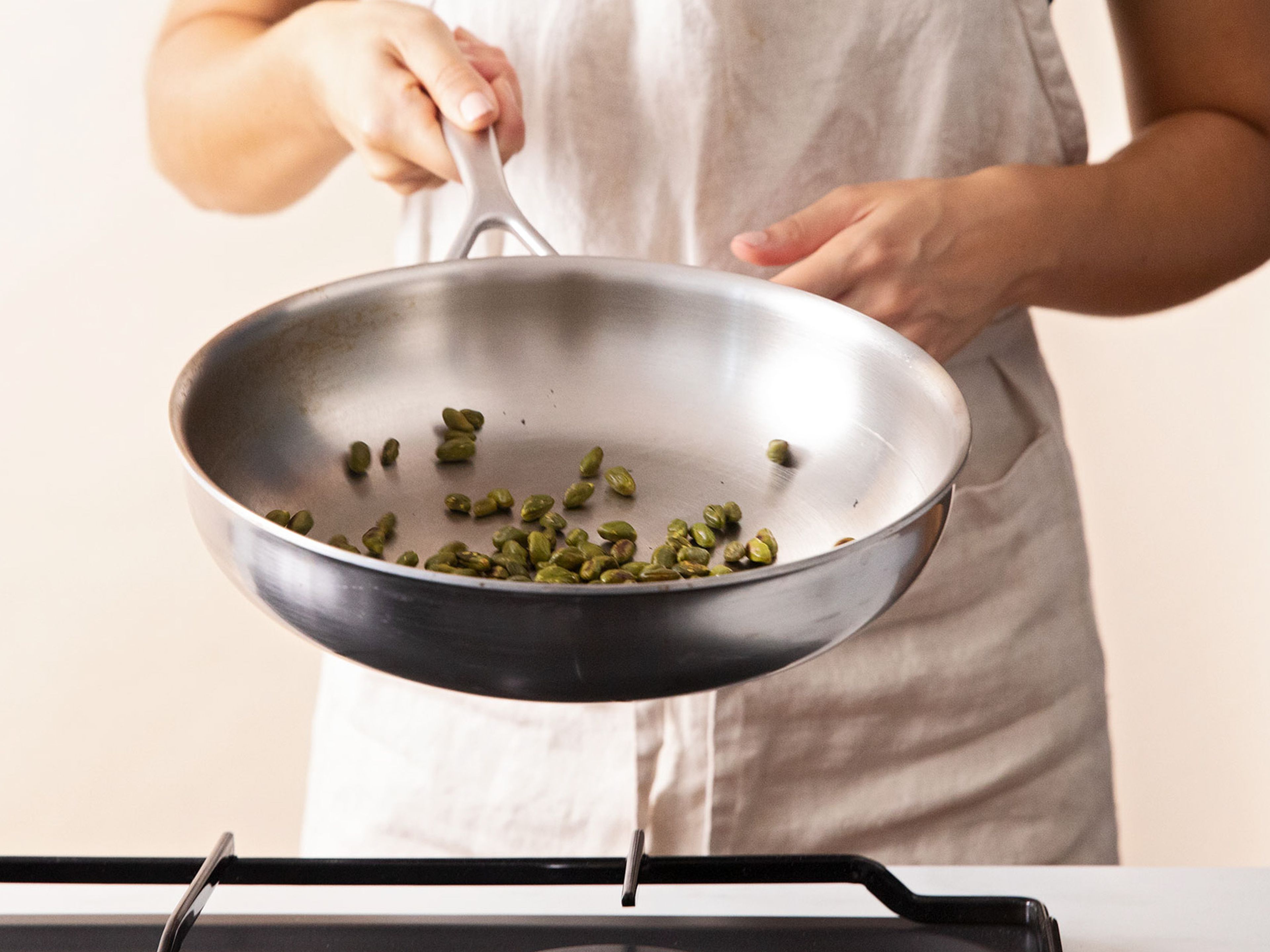 In a frying pan, toast pistachios until fragrant over medium heat. Set aside to cool. In the meantime, combine sugar and water in a saucepan over medium heat, stirring to dissolve the sugar. Allow to simmer until the mixture starts to bubble, approx. 7 min.