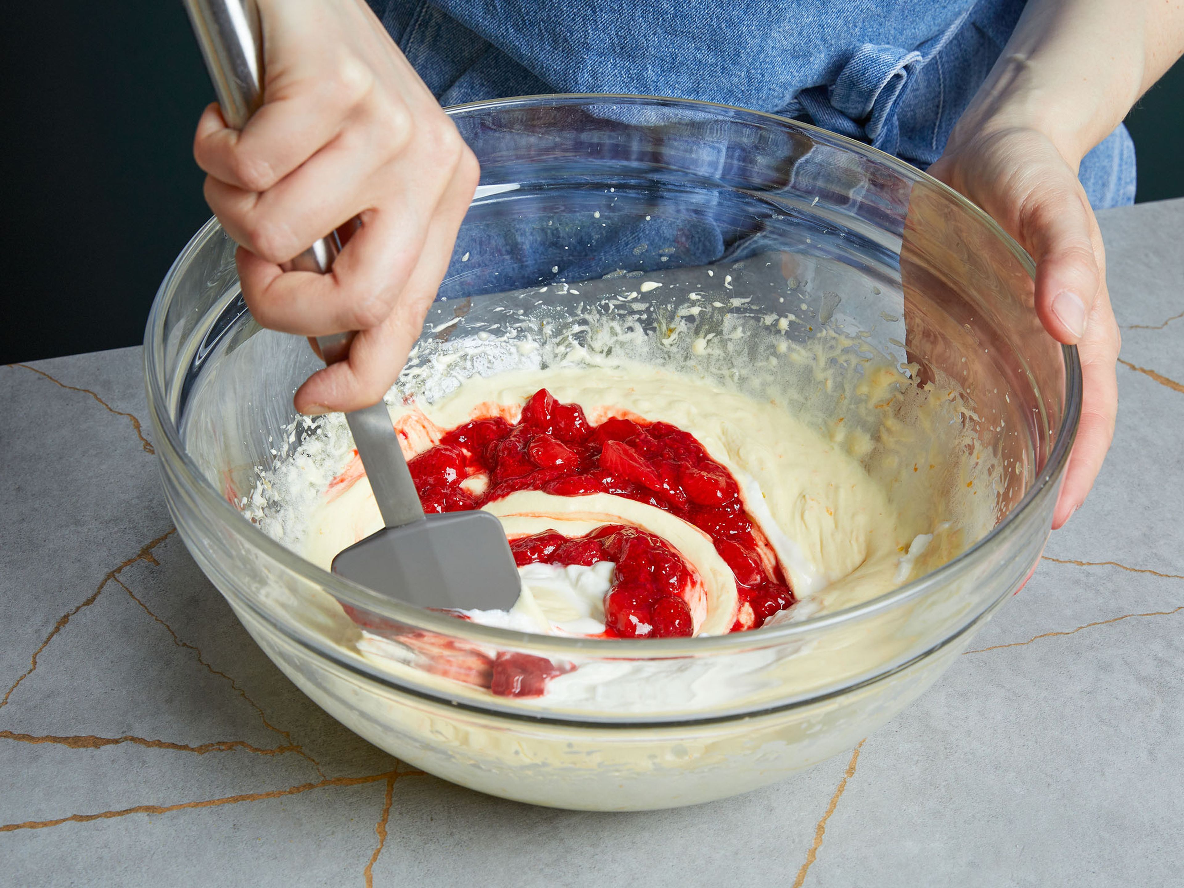 Preheat the oven to 180°C/356°F. Mix flour, baking powder, and salt in a large bowl. In another bowl, whisk sugar, melted butter, orange zest, vanilla extract, and eggs for approx. 1 min. until light and fluffy. Add yogurt and strawberry compote and mix. Then fold into the flour mixture and add half of the remaining strawberries, setting some aside for decorating the top. Be careful not to overmix the dough.