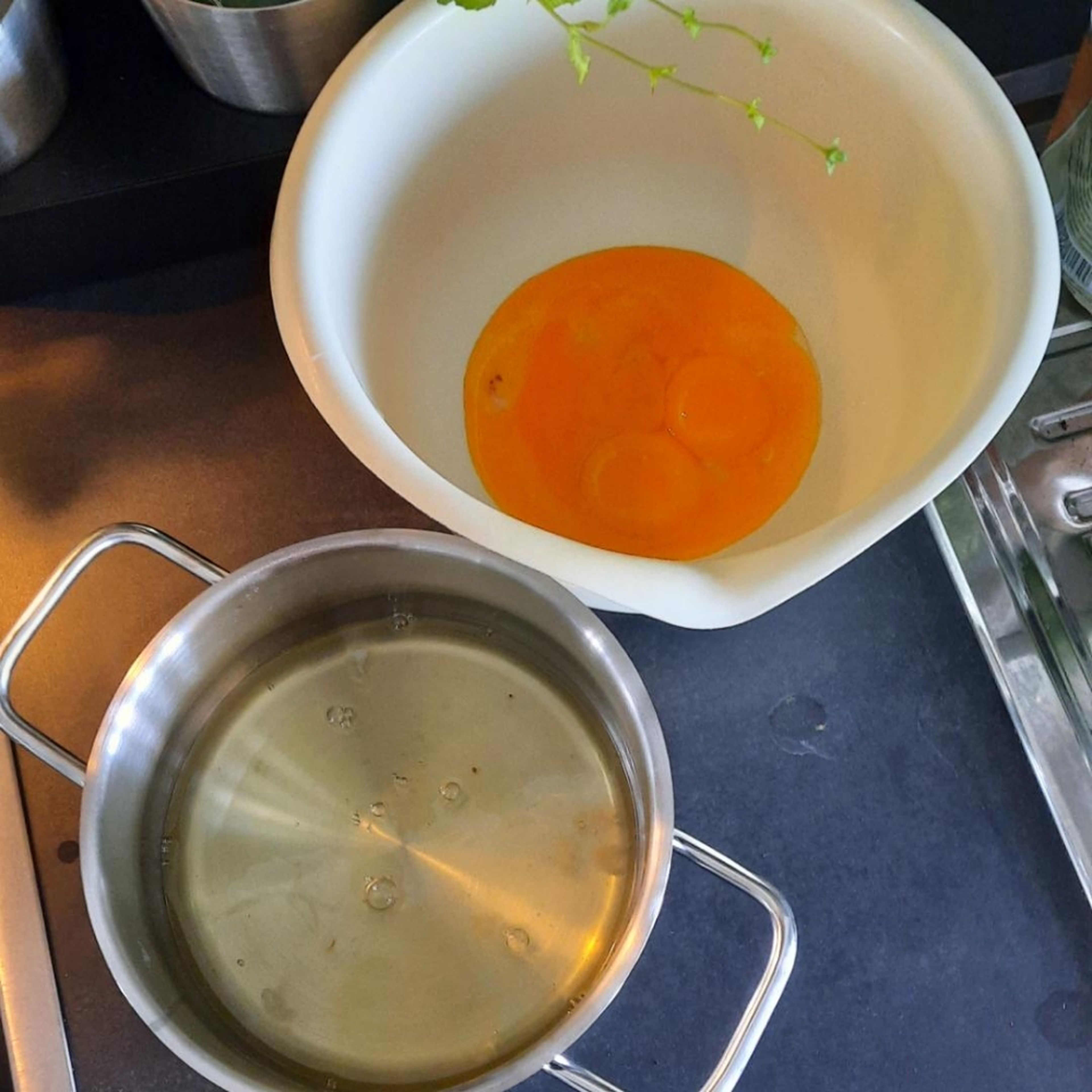 Backofen auf 180°C Umluft vorheizen. Die Eier trennen. Das Eigelb in eine große Schüssel geben und mit Wasser schaumig schlagen. 75g Zucker und Vanillezucker langsam einrieseln lassen und weiter schaumig schlagen.