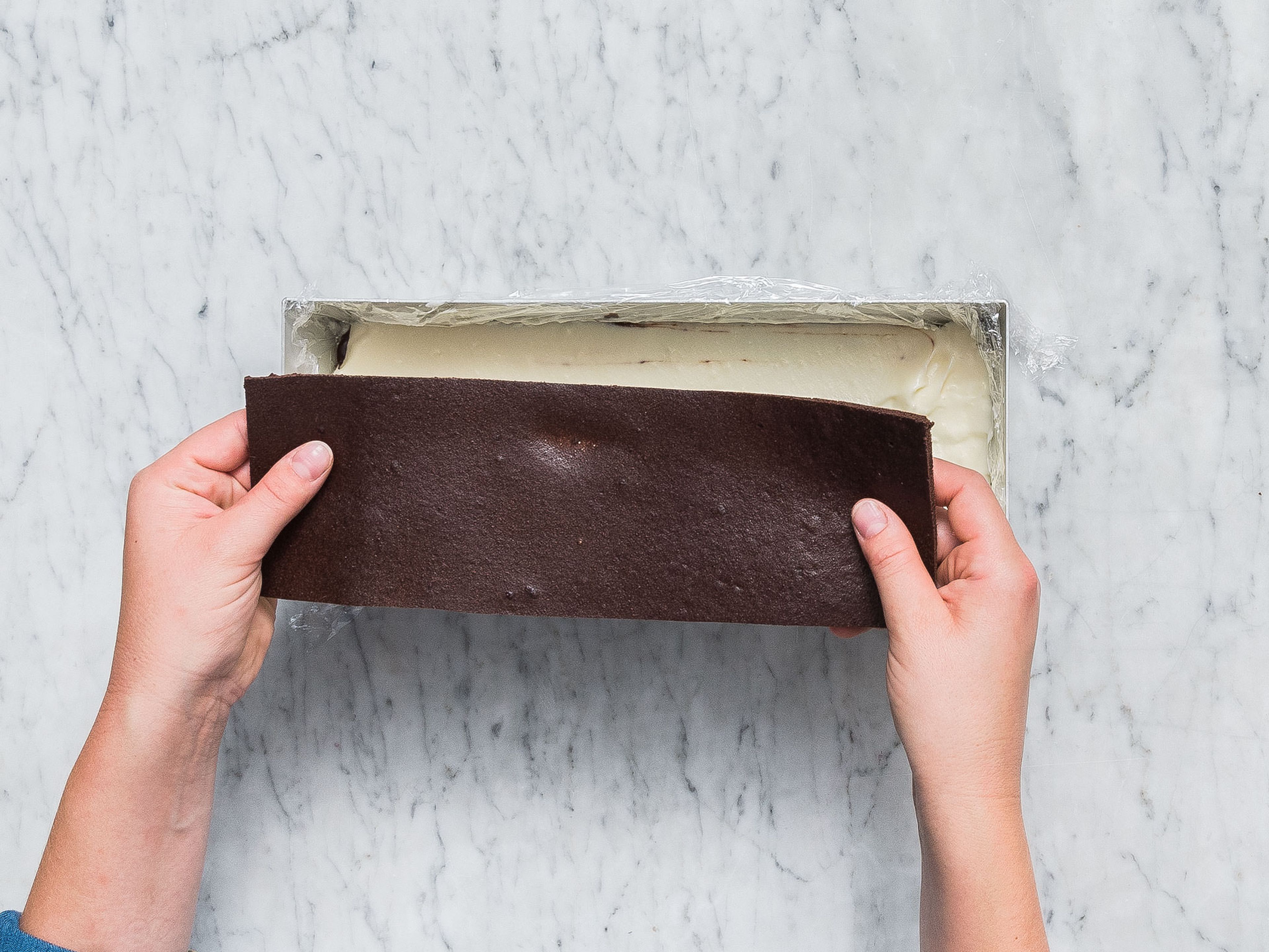 Die restliche Mascarponecreme auf der gekühlten Schokoladenglasur verteilen und den zweiten Kuchenboden darauflegen. Erneut ca. 60 Min. im Kühlschrank ruhen lassen.