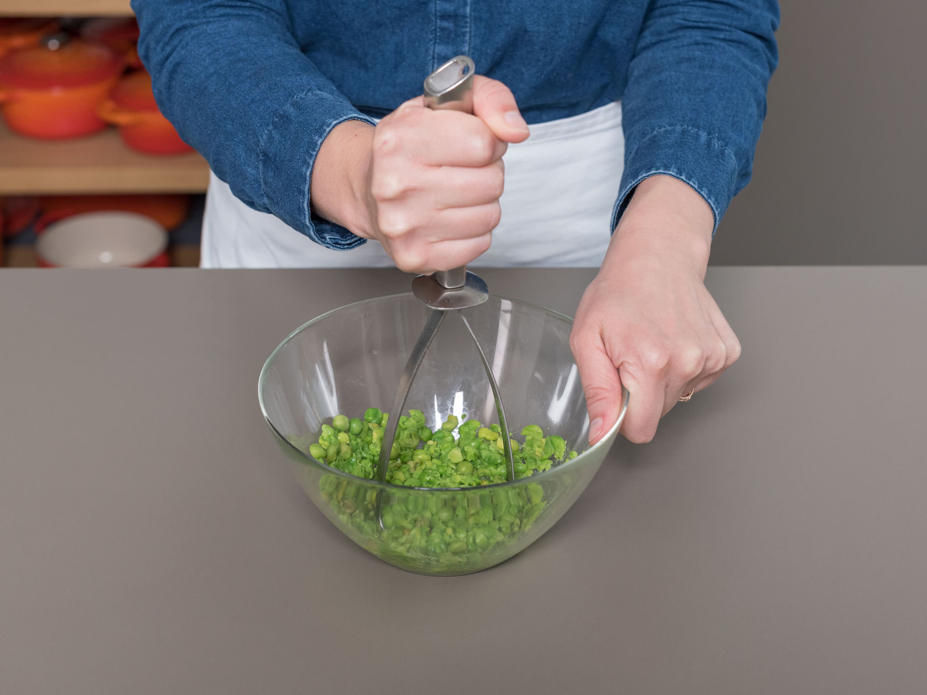 In a large bowl, defrost peas in boiling water for approx. 2 min., then drain and roughly mash with a potato masher.