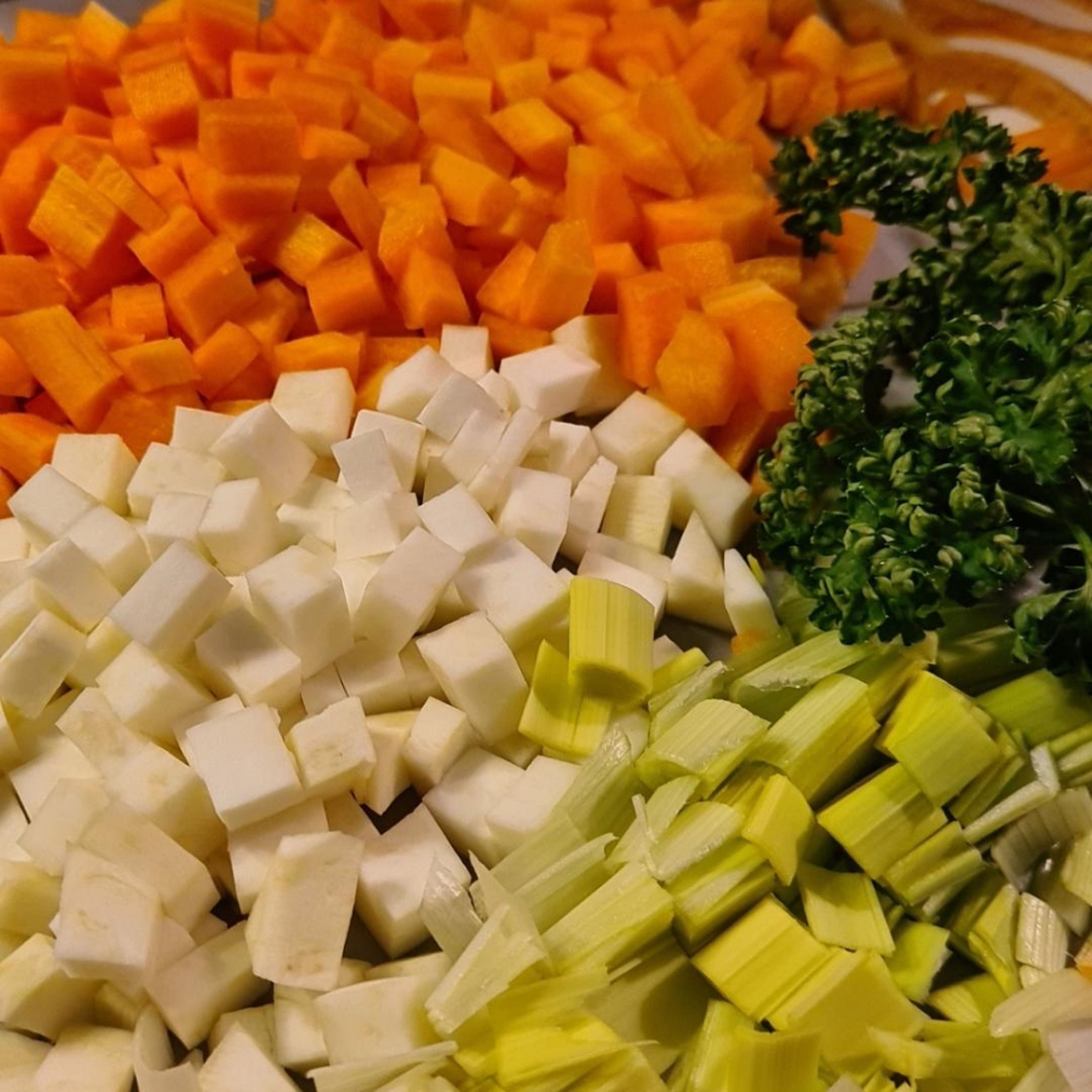 Zunächst das Suppengrün Gemüse und die Zwiebeln kleinschneiden.