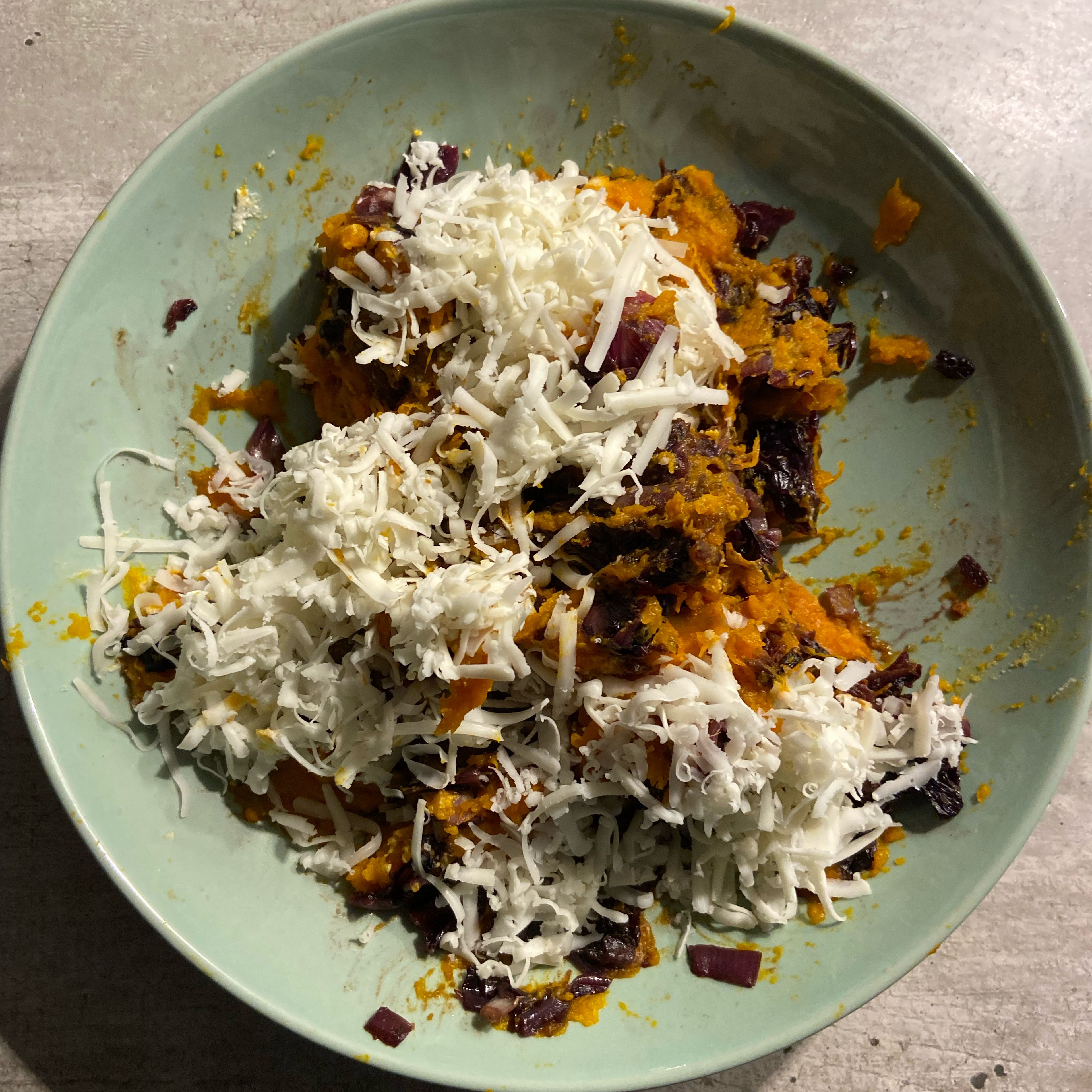 Add the smashed pumpkin, the cooked radicchio, walnuts, grated cheese and Parmesan to a bowl. Mix well all the ingredients with a spoon.