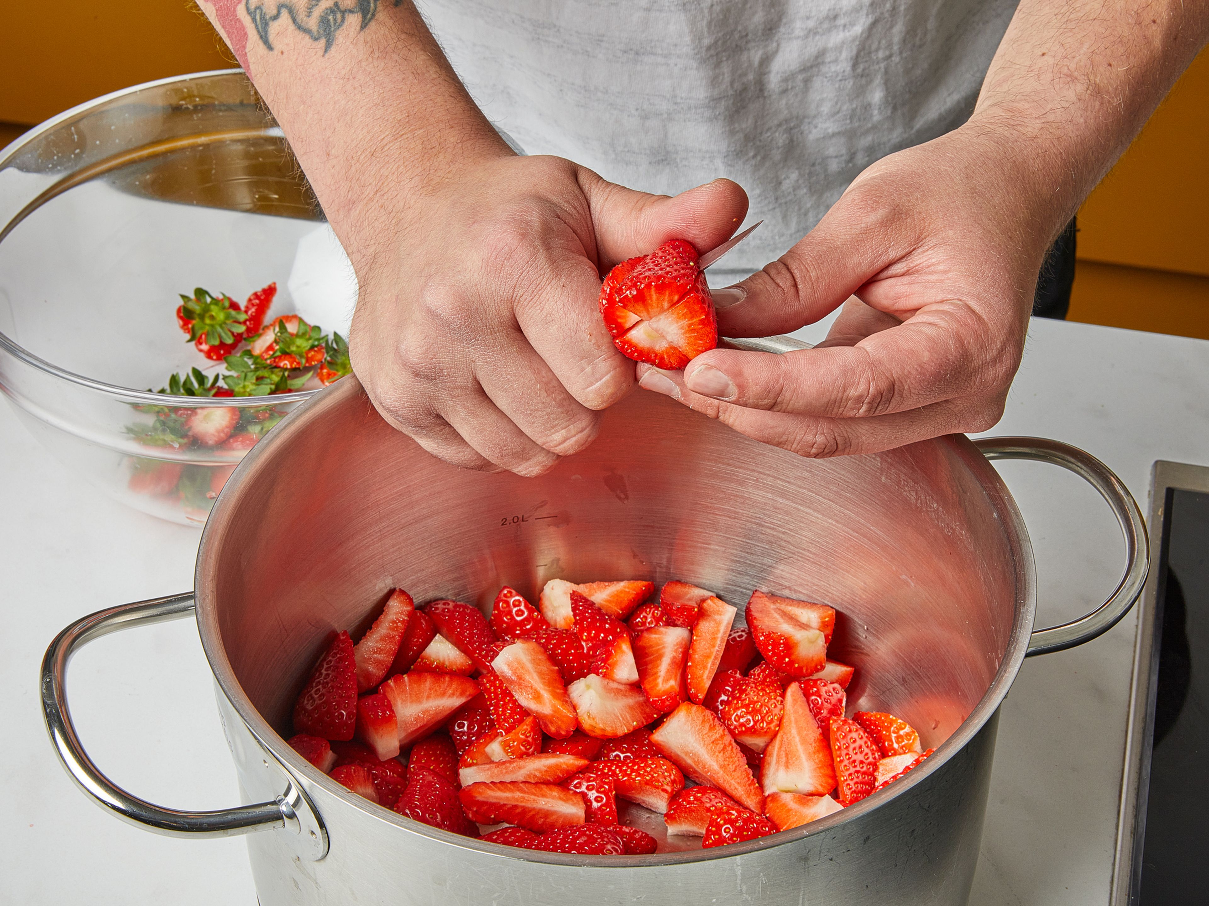 Einen kleinen Teller für die spätere Gelierprobe in die Gefriertruhe legen. Die Erdbeeren waschen und in Viertel schneiden. In einem großen Topf, Gelierzucker und Erdbeeren gut miteinander vermischen. Die gezuckerten Früchte anschließend für ca. 1 Std. stehen lassen, um sie etwas Saft ziehen zu lassen.