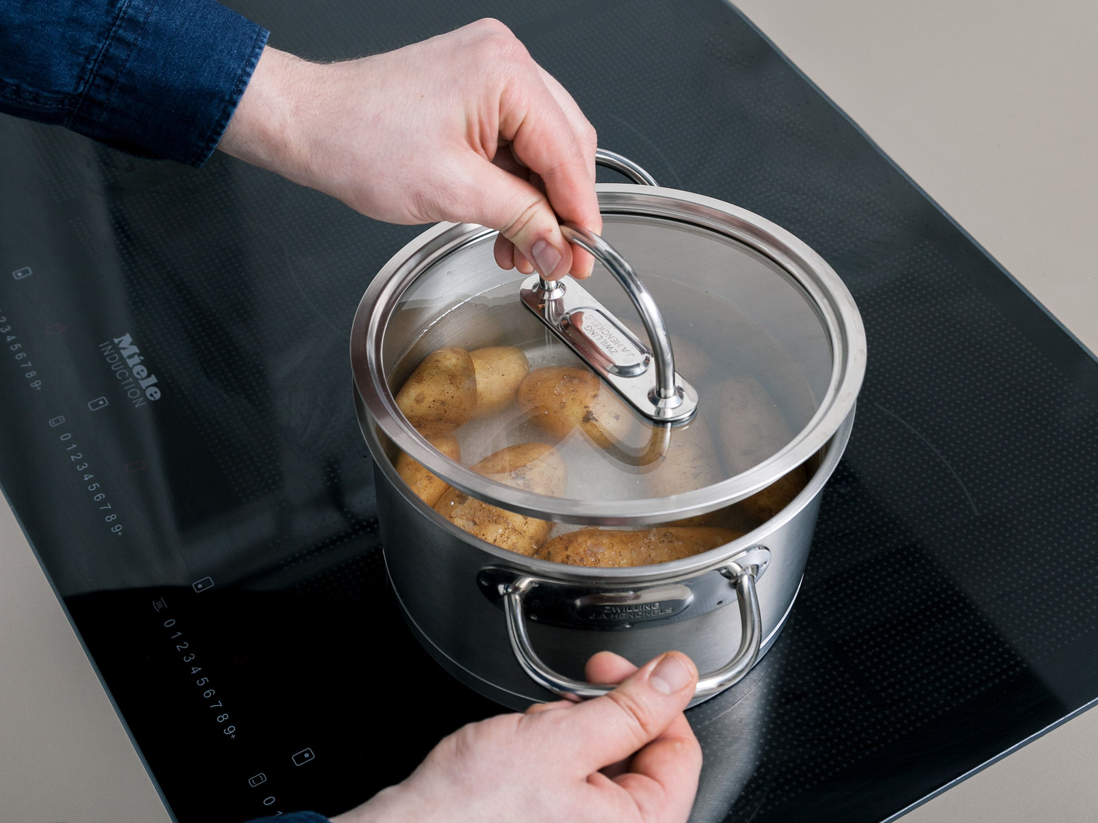 Frühkartoffeln waschen und zusammen mit Meersalz in einen Topf geben. Mit Wasser auffüllen, bis die Kartoffeln vollständig bedeckt sind. Abgedeckt für ca. 25 Min. kochen lassen.
