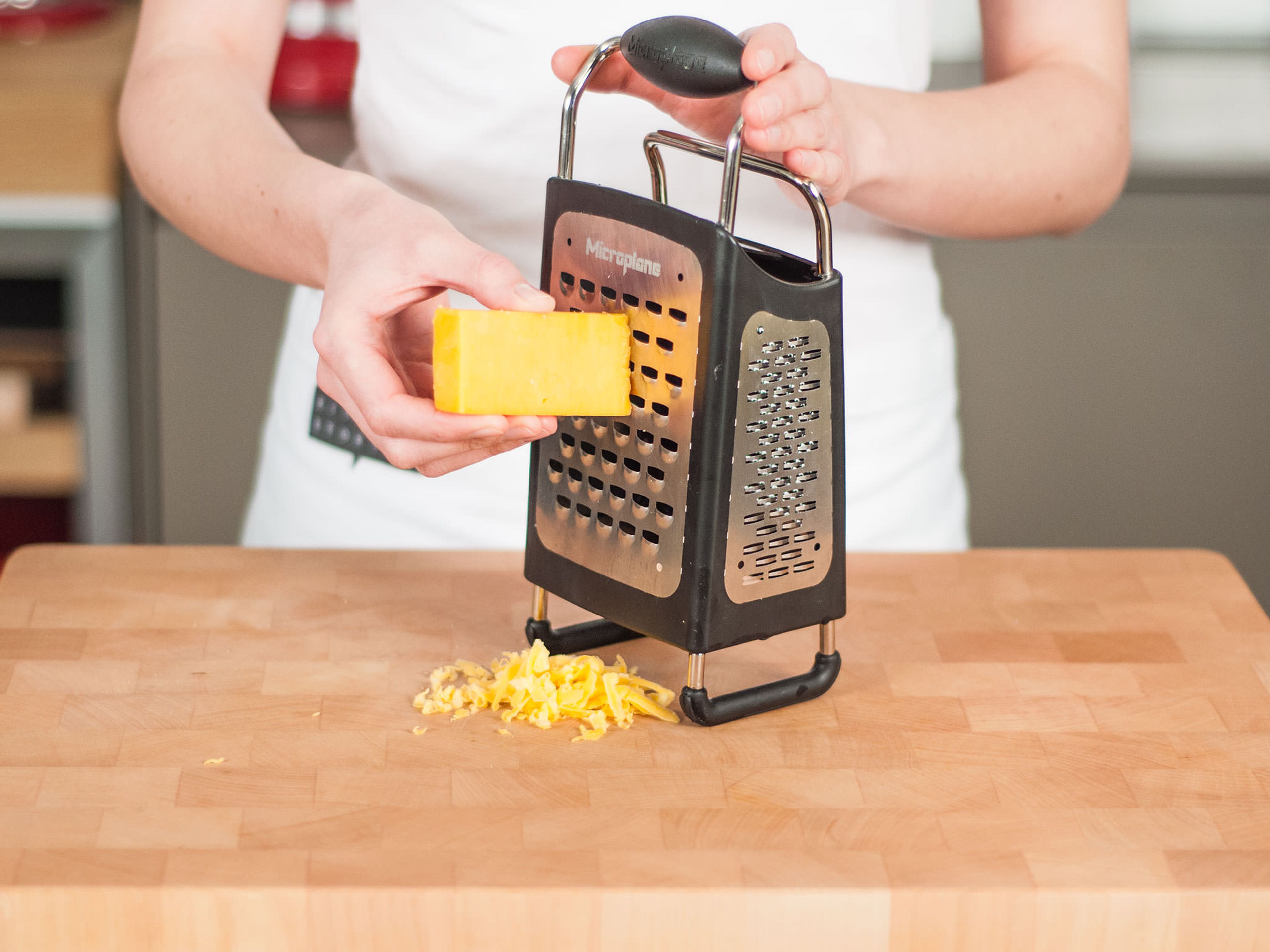 Using a box grater, roughly grate cheese.
