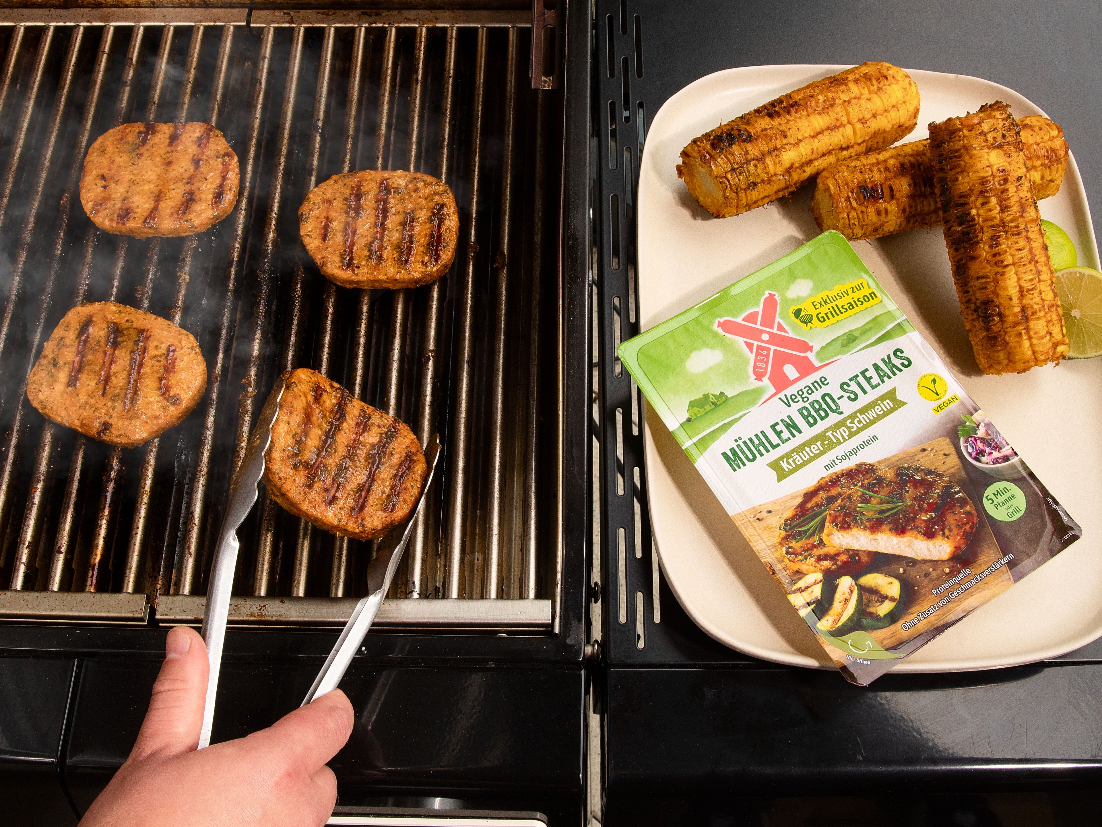 Den marinierten Mais ca. 5–8 Min. grillen, bis er dunkle Grillstreifen bekommt, dabei mehrmals wenden. Vom Grill nehmen und etwas abkühlen lassen. Dann die Veganen Mühlen BBQ-Steaks Kräuter – Typ Schwein von der Rügenwalder Mühle auf den Grill legen und bei mittlerer, indirekter Hitze ca. 5 Min. grillen und dabei nach Bedarf wenden. Vom Grill nehmen und in Streifen schneiden. Den gegrillten Mais vom Kolben schneiden. Den Mais, das Gemüse und ¾ des Korianders in eine große Schüssel geben, das Limetten-Dressing darüber geben und vermischen. Die Steakstreifen darauf anrichten und zum Servieren mit dem restlichen Koriander garnieren.