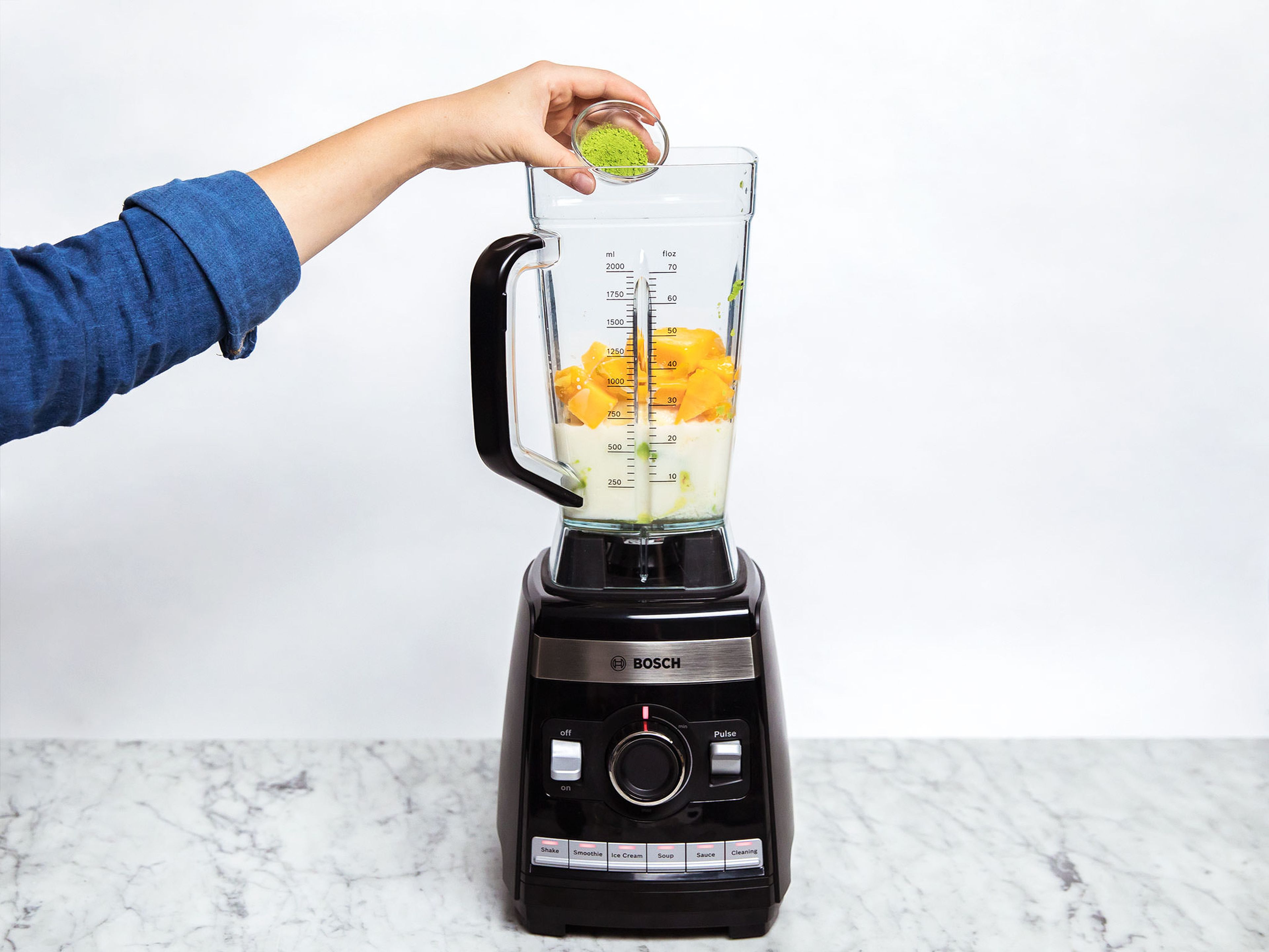 Halve the avocado and remove the seed. Scoop the flesh of both halves into the blender. Peel and add bananas to the blender with the frozen mango, freshly squeezed lime juice, agave nectar, almond milk, and matcha powder. Blend until smooth (using your blender's smoothie function).