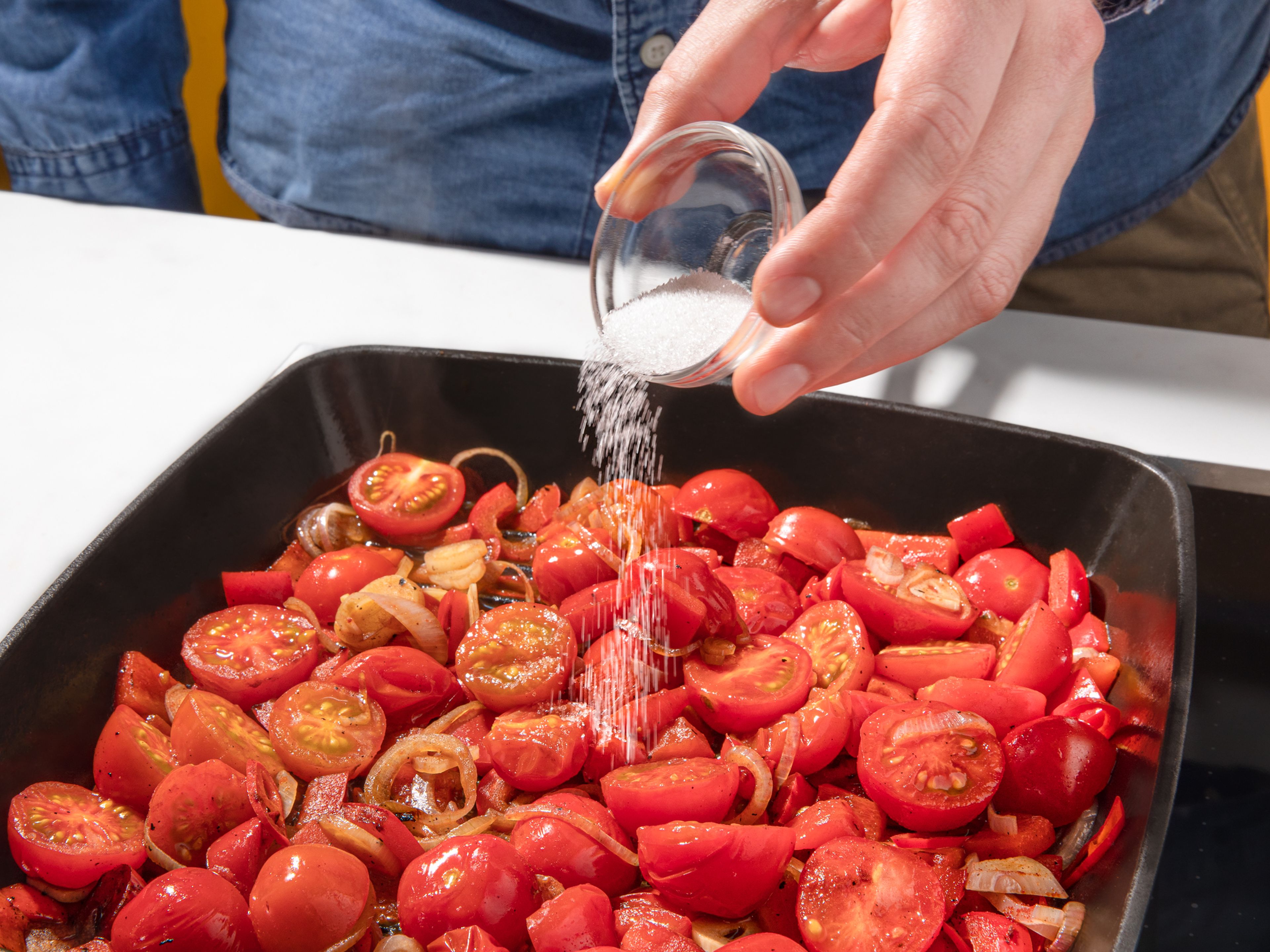 In der gleichen Pfanne dann die Paprika grillen bis sie etwas Farbe bekommt. Knoblauch, Tomaten, Chili und Schalotten beifügen. Mit 100ml Wasser ablöschen und unter Rühren köcheln lassen. Nach 5-7 Minuten geräuchertes Paprikapulver, Worchestersauce und Zucker hinzufügen. Weiterhin etwas köcheln lassen.