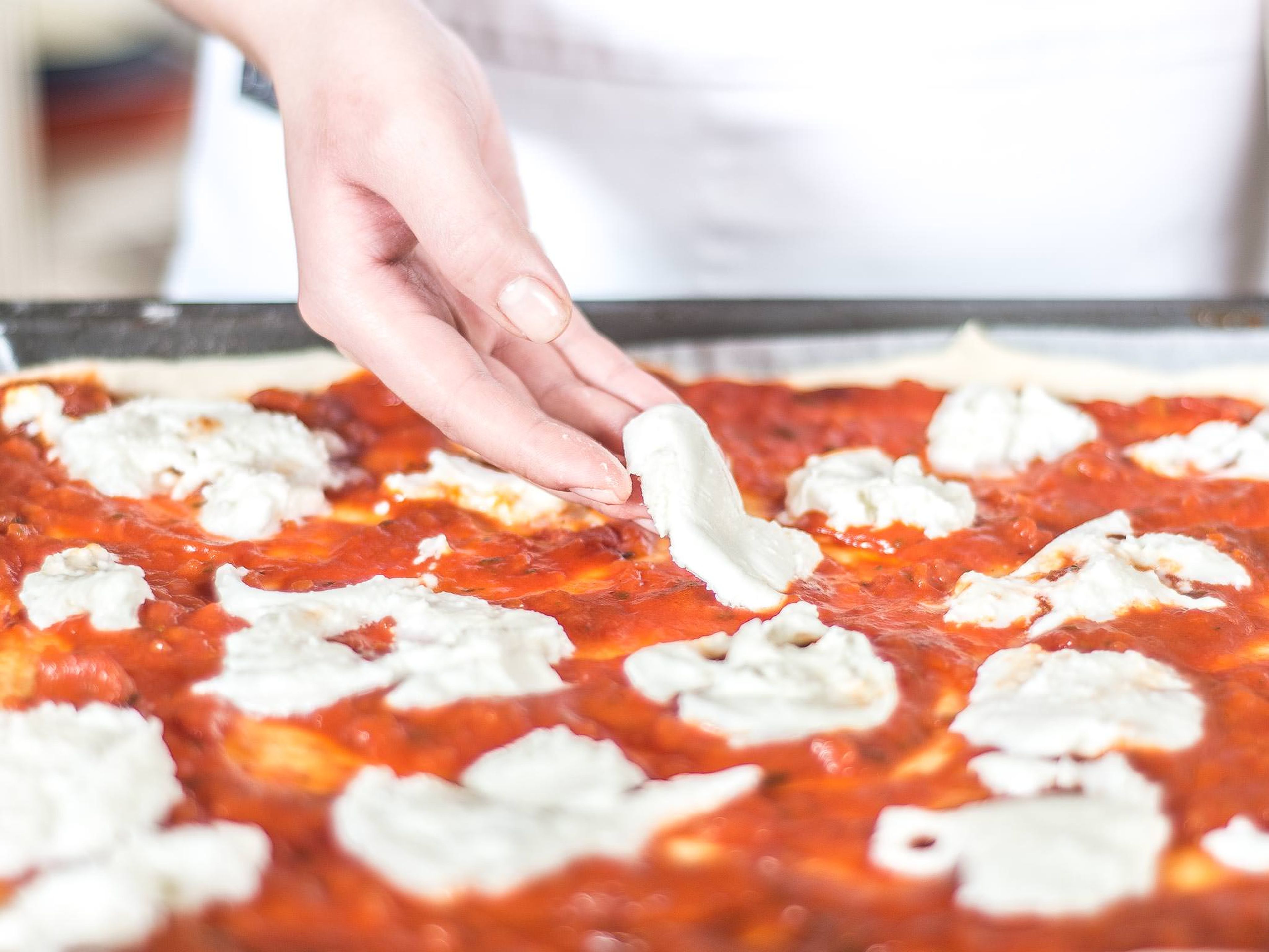 Den Mozzarella nun in Scheiben schneiden und gleichmäßig auf der Pizza verteilen. Anschließend die Pizza im vorgeheizten Backofen bei 180°C für ca. 20–25 Minuten goldbraun backen.