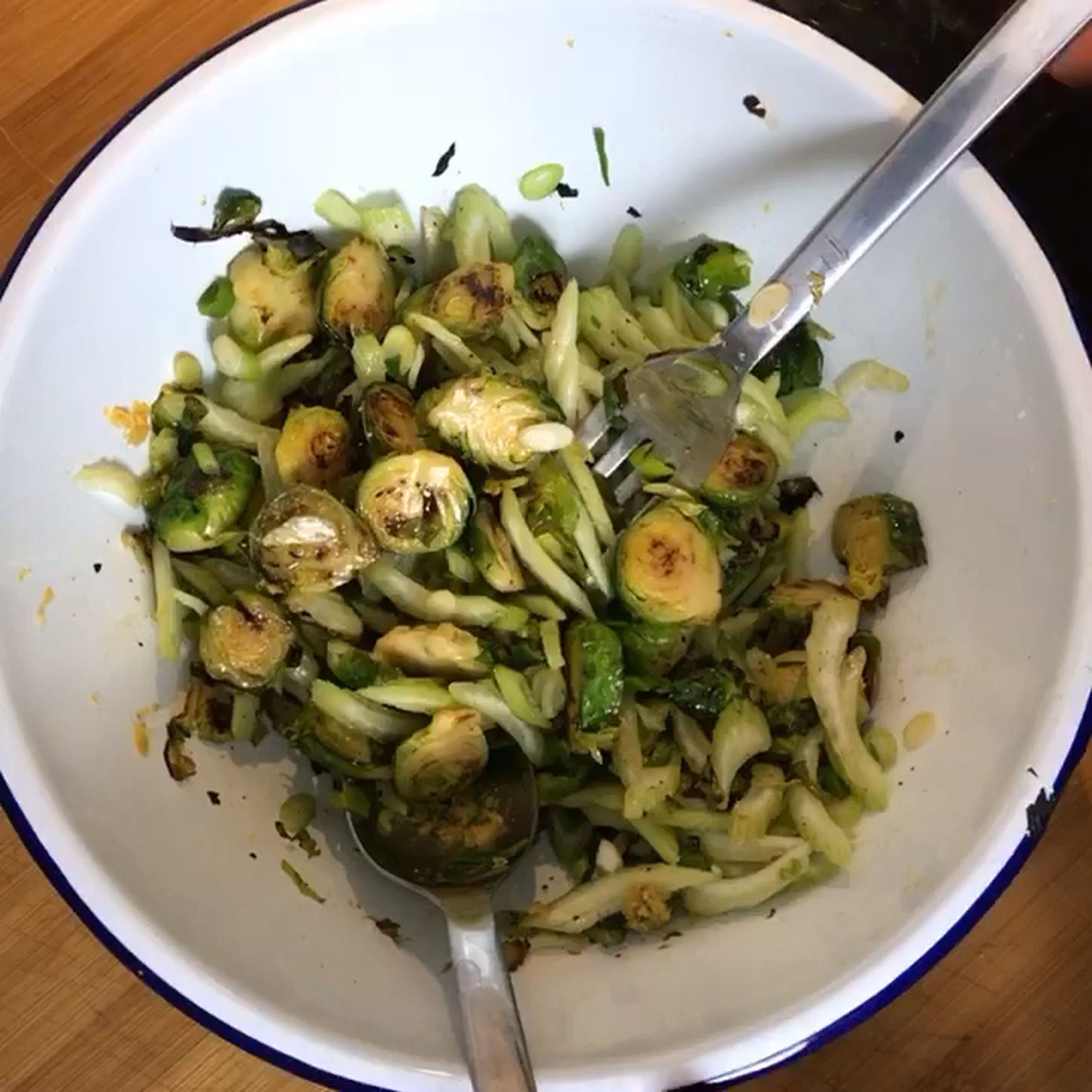Mix the fried Brussels sprouts in a bowl with celery and spring onions. Then add salt, pepper, lemon zest and juice and mix.