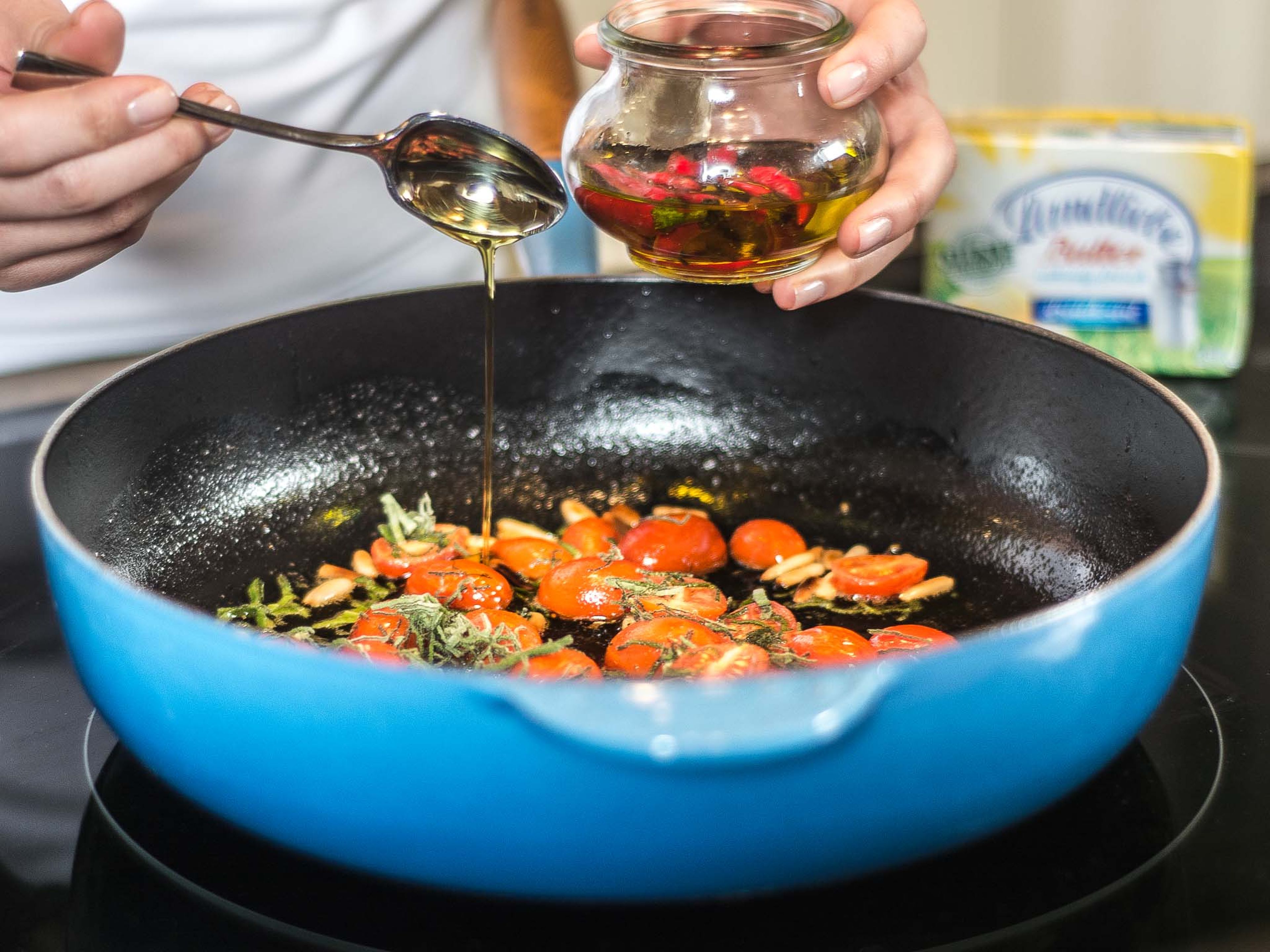 Melt butter in a large frying pan. Add sage, cherry tomatoes, pine nuts, and chili oil and fry. Season lightly with salt and pepper.