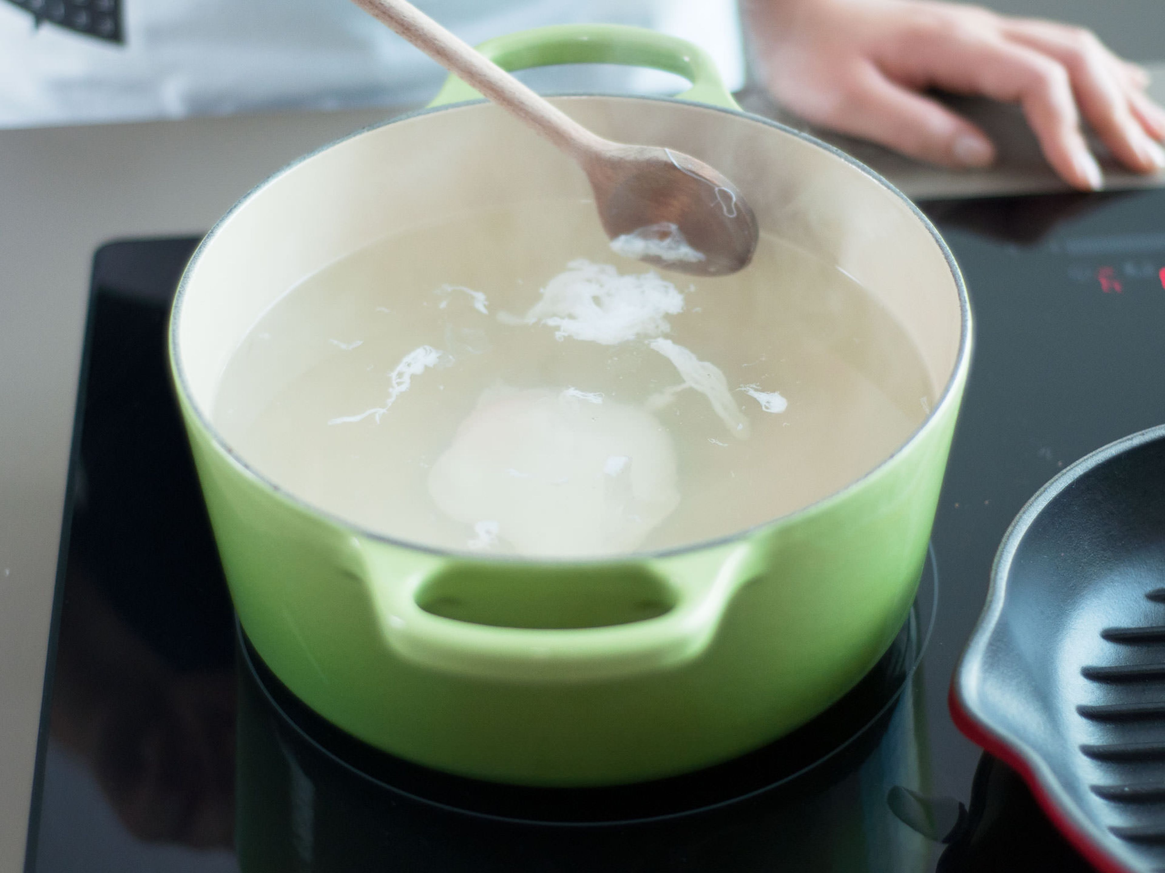 In a medium saucepan, bring salted water to a boil. Then reduce heat and add white vinegar. Crack eggs into separate cups. Stir water continuously with a cooking spoon to form a whirlpool. Then carefully pour eggs, one by one, into water. Cook eggs for 3 – 4 min, then use a slotted spoon to gently remove from water.