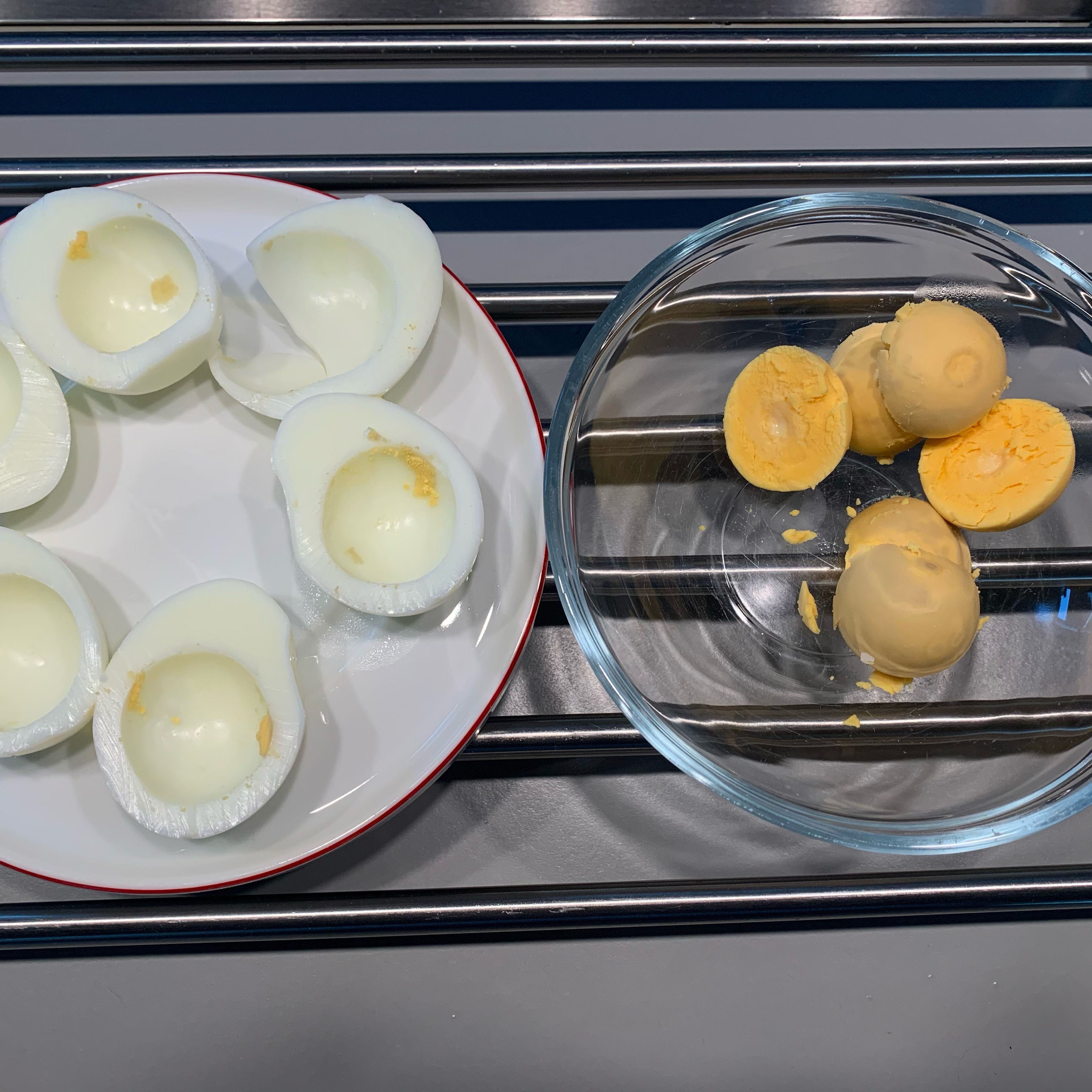 Die Eier 12 Minuten kochen, mit kaltem Wasser abschrecken, pellen￼, halbieren, das Eigelb in eine kleine Schüssel geben.￼