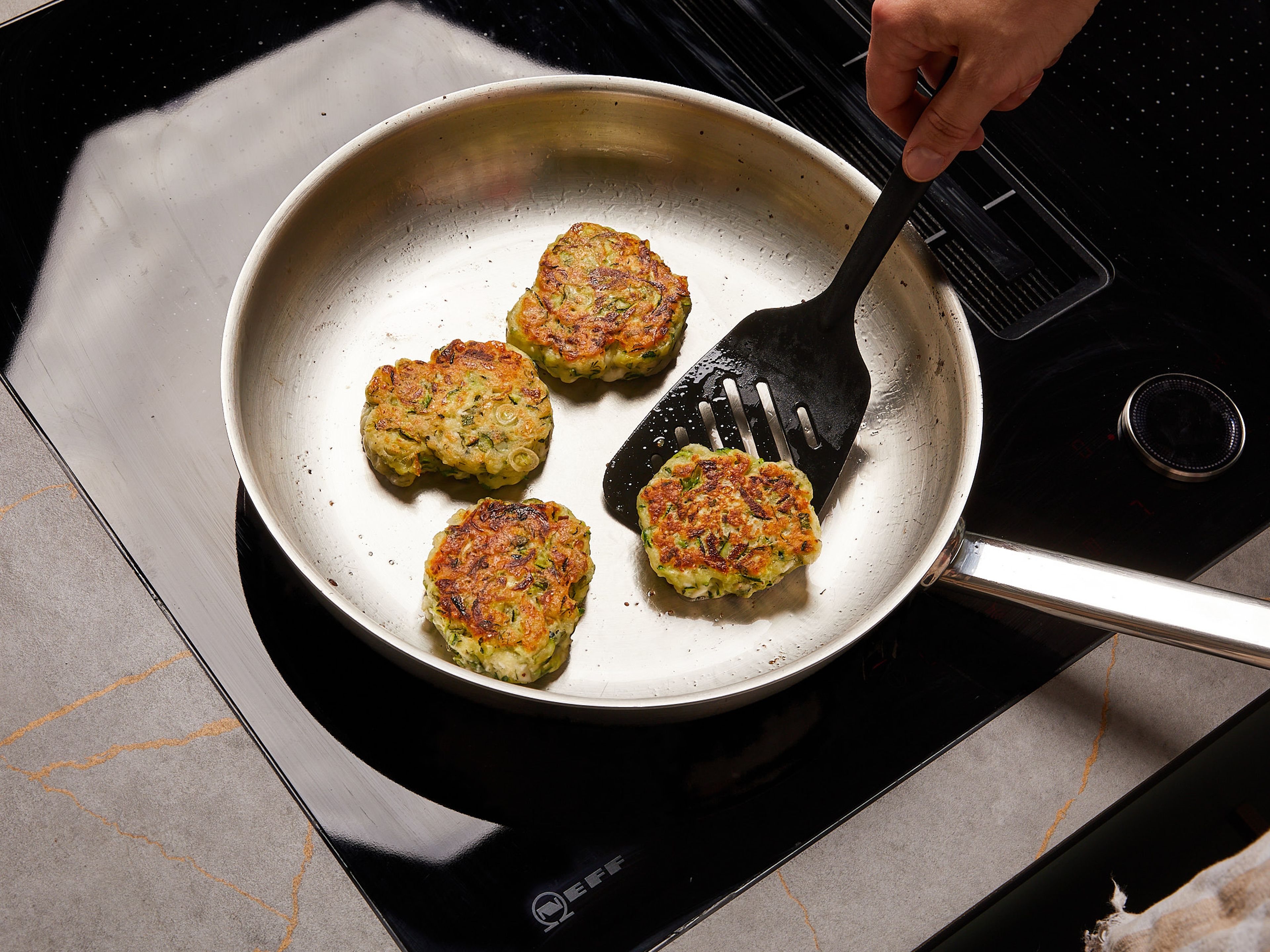 Heat oil in a skillet over medium-high heat and fry 2 tbsp of the zucchini mixture at a time, forming a fritter shape. Turn each over after approx. 3–4 min or when it starts to turn golden brown. Transfer to a plate lined with paper towels to drain.