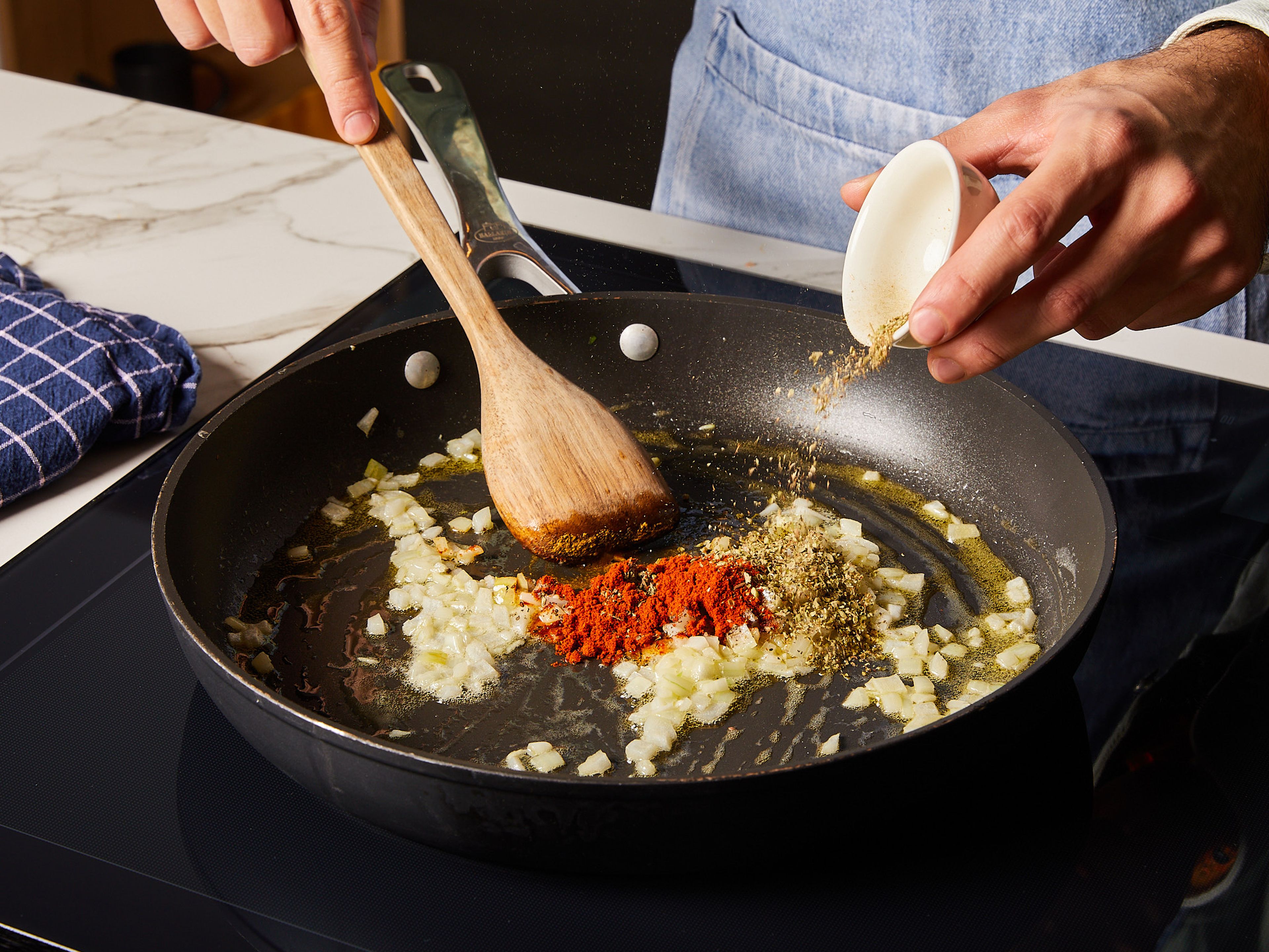 Zuerst die Zwiebel würfeln und den Knoblauch reiben. Öl, Butter, Zwiebel und Knoblauch in eine große Pfanne geben. Sobald das Öl heiß ist, Kreuzkümmel, Cayennepfeffer, Oregano, Basilikum, Salz und Pfeffer hinzufügen. Bei mittlerer Hitze unter ständigem Rühren ca. 5 Min. lang anbraten. Tomatenmark hinzugeben und knapp ca. 1 Min. lang rühren, bis alles gut vermischt ist.