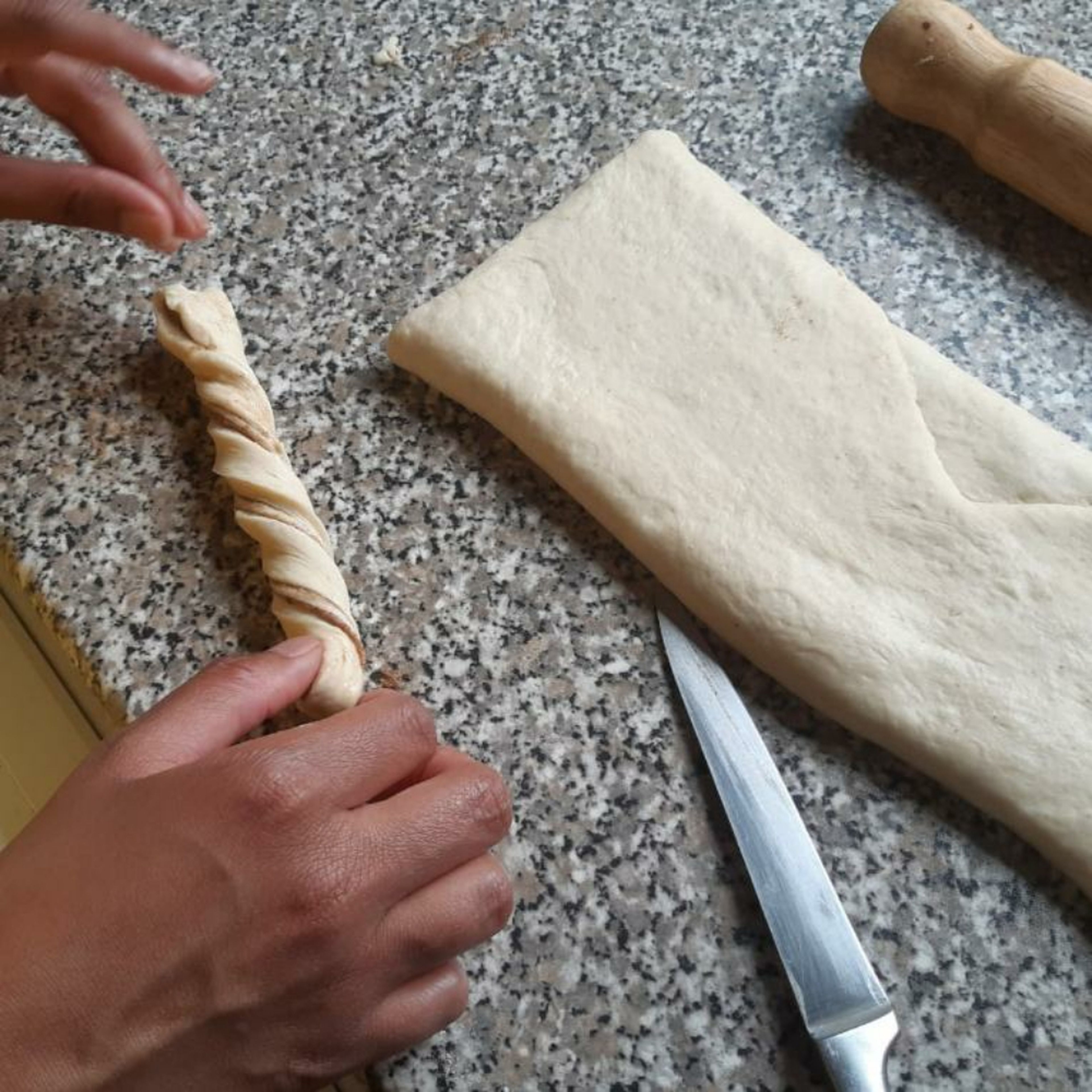 Grab one end and twist, whilst slightly stretching from the other end (don't over stretch, causing the dough to separate). (Number of buns dependen the size of dough rolled and strips cut).
