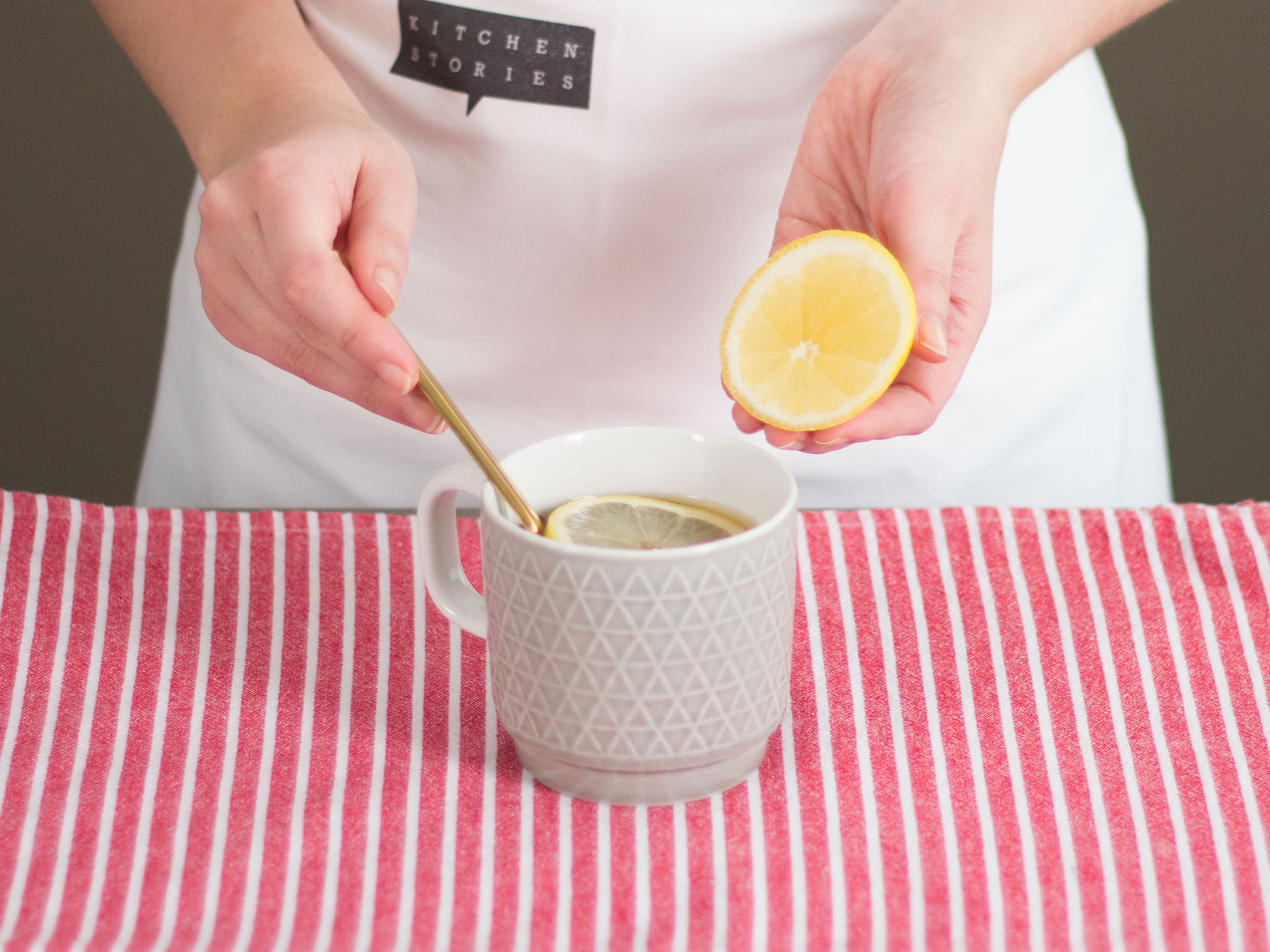 Weinbrand und Zitronenscheiben in die Tasse geben und vorsichtig umrühren.