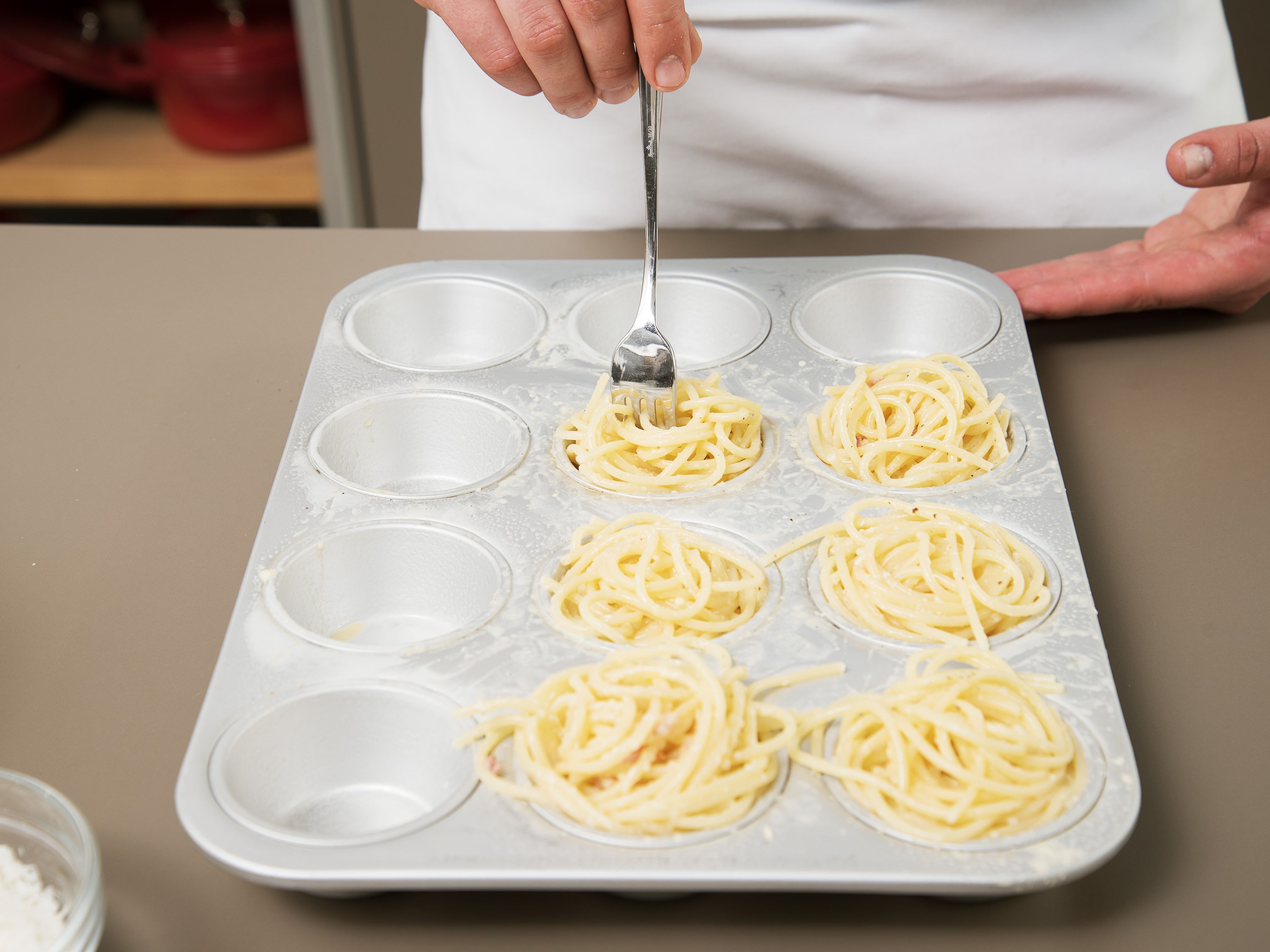 Grease the muffin tin. Twirl spaghetti strands around a fork and place into muffin cups. Sprinkle with the remaining Parmesan cheese, then bake at 180°C/350°F (convection) for approx. 15 – 20 min.