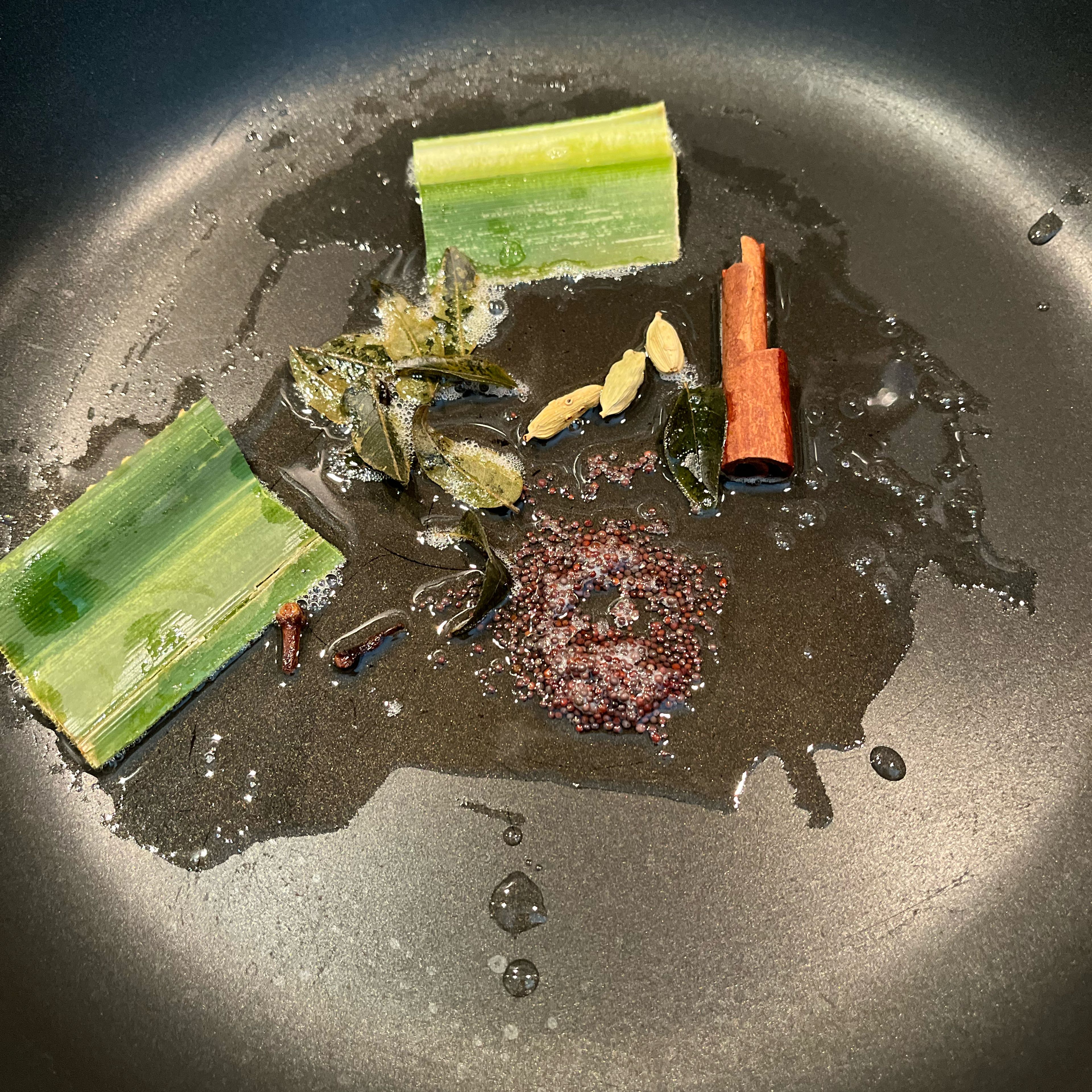 Heat oil in a nonstick pan. Add mustard seeds, cinnamon, cardamom, cloves, pandan and curry leaves. Heat up until mustard seeds pop.