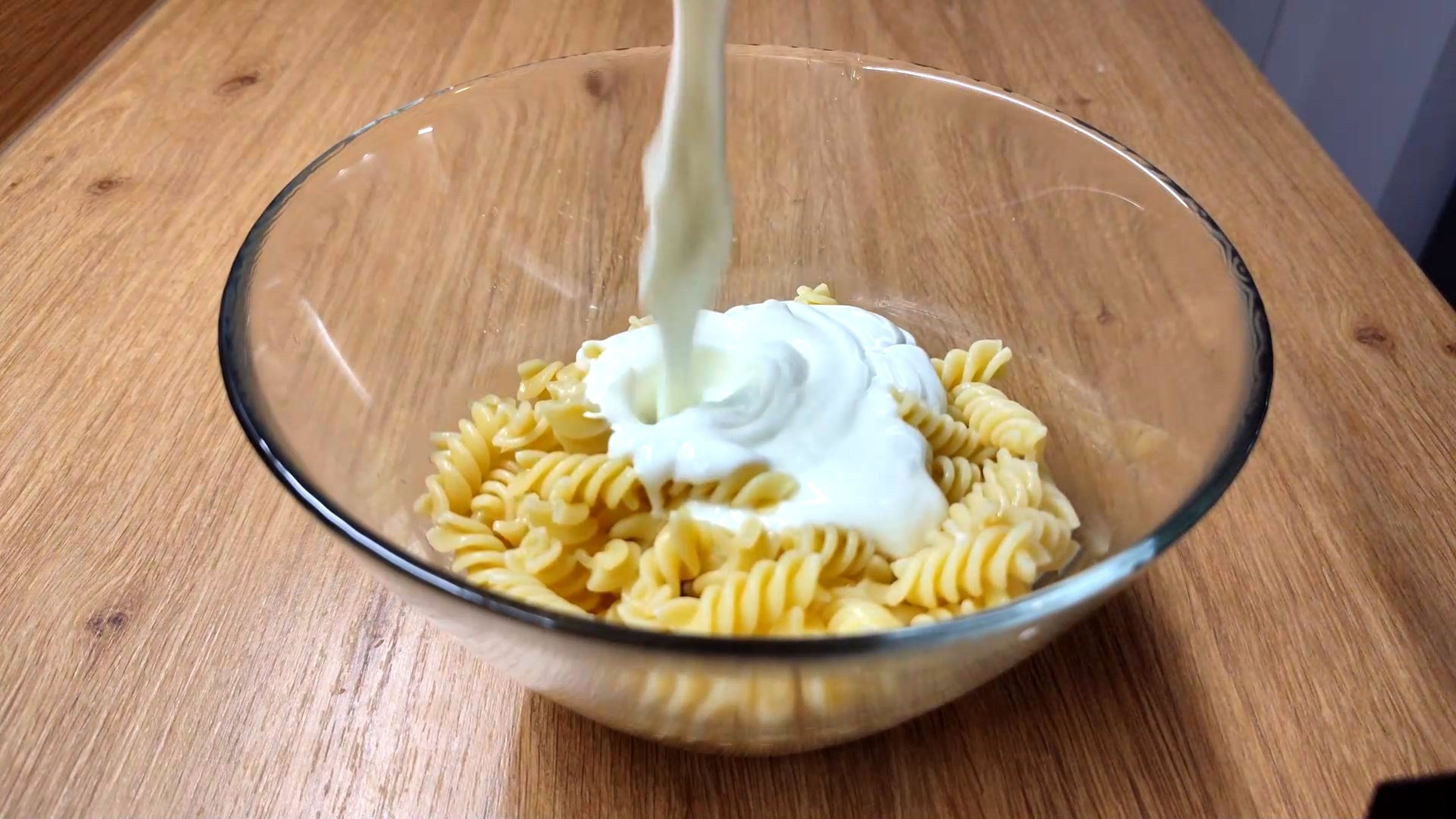 Wenn die Nudeln bissfest sind, diese abschütten und abtropfen lassen. Im Anschluss mit dem mit Knoblauch angereicherten Joghurt vermengen.