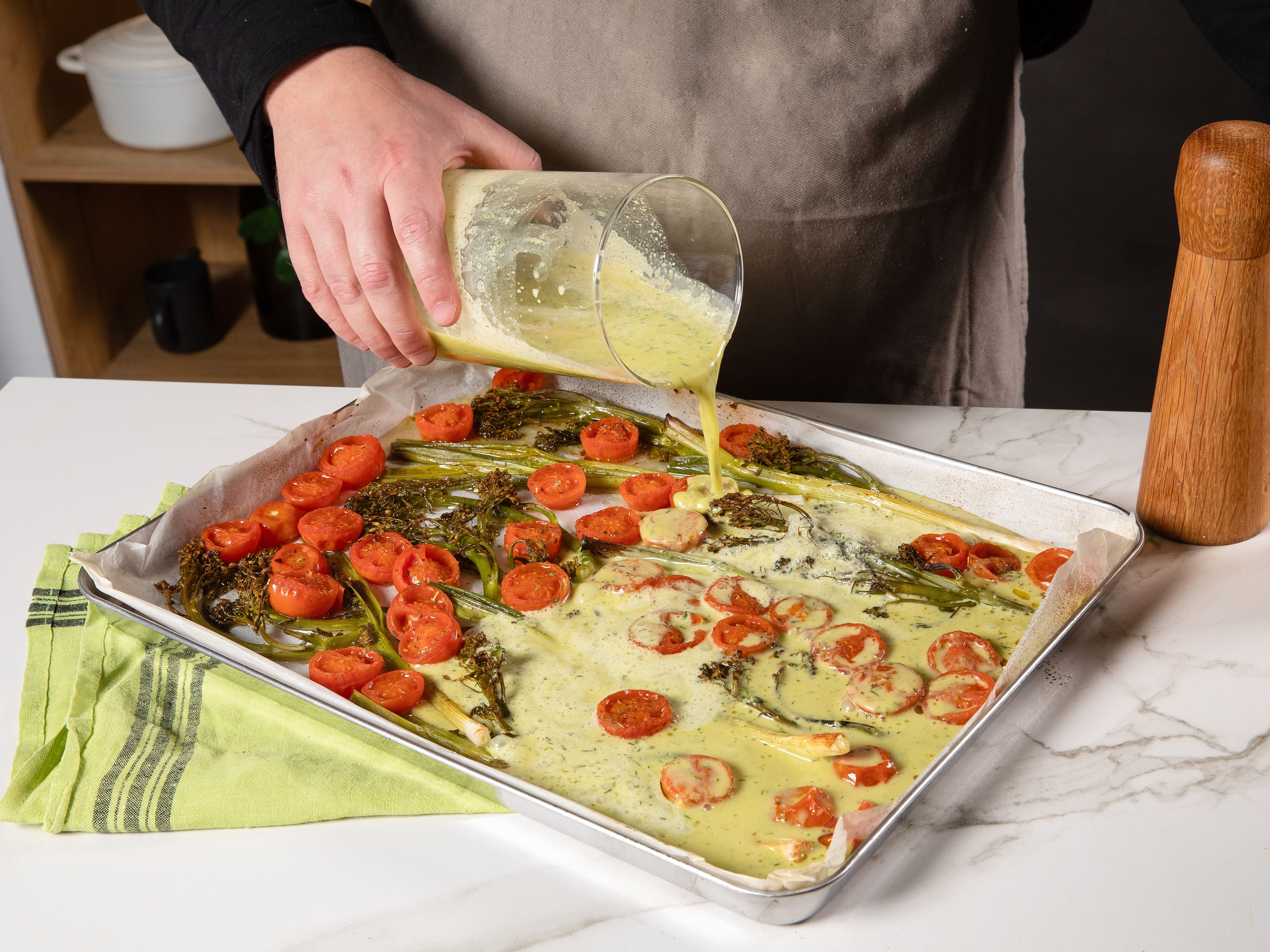 Wenn das Gemüse gar ist, den Ofen auf 160 °C herunterdrehen. Die Eiermischung über das Gemüse geben und weitere ca. 20 Min. backen, bis die Eier gestockt sind. Aus dem Ofen nehmen und zum Servieren mit frischen Kräutern toppen.