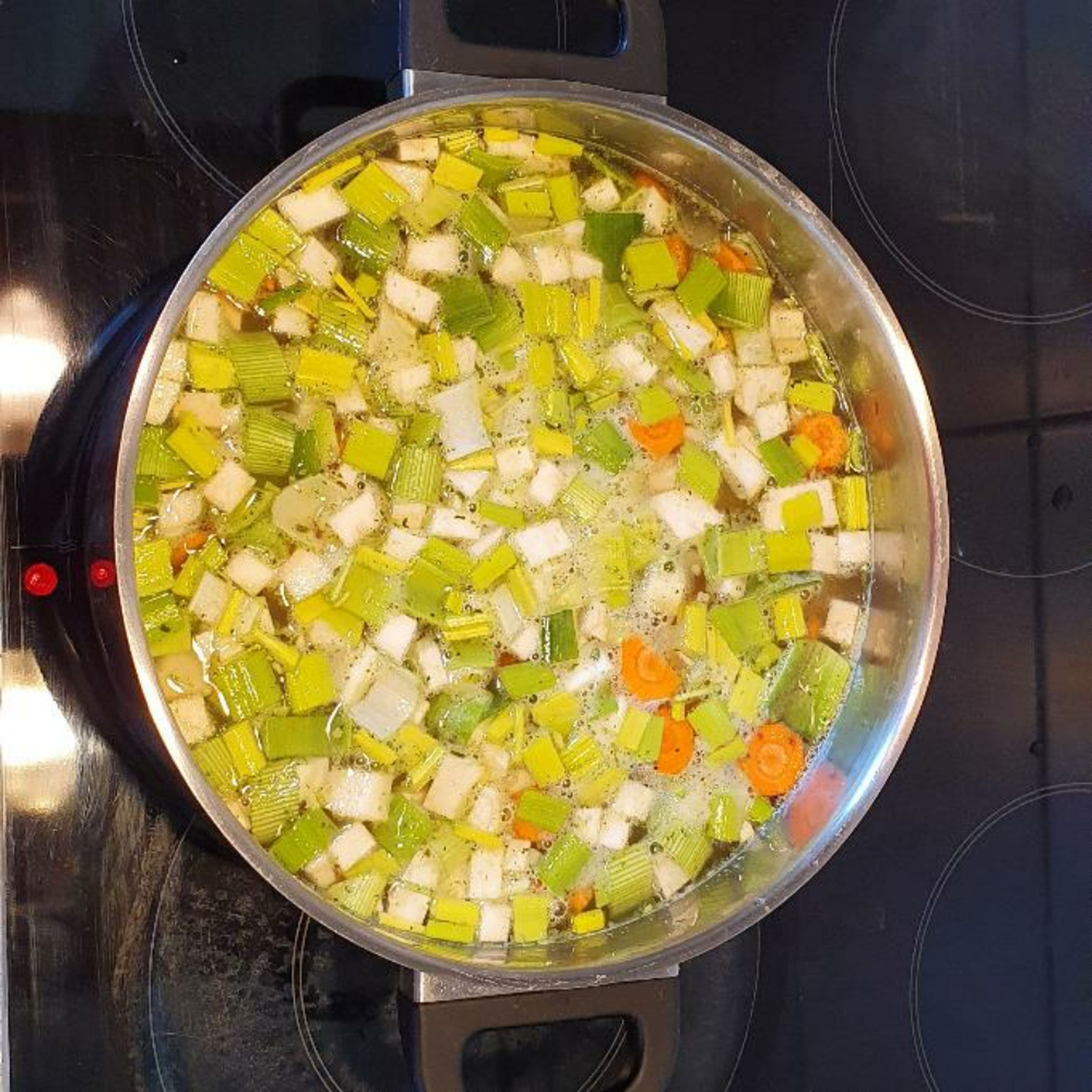 Kartoffeln und Suppengrün zusammen mit der Gemüsebrühe 20 Minuten köcheln lassen.