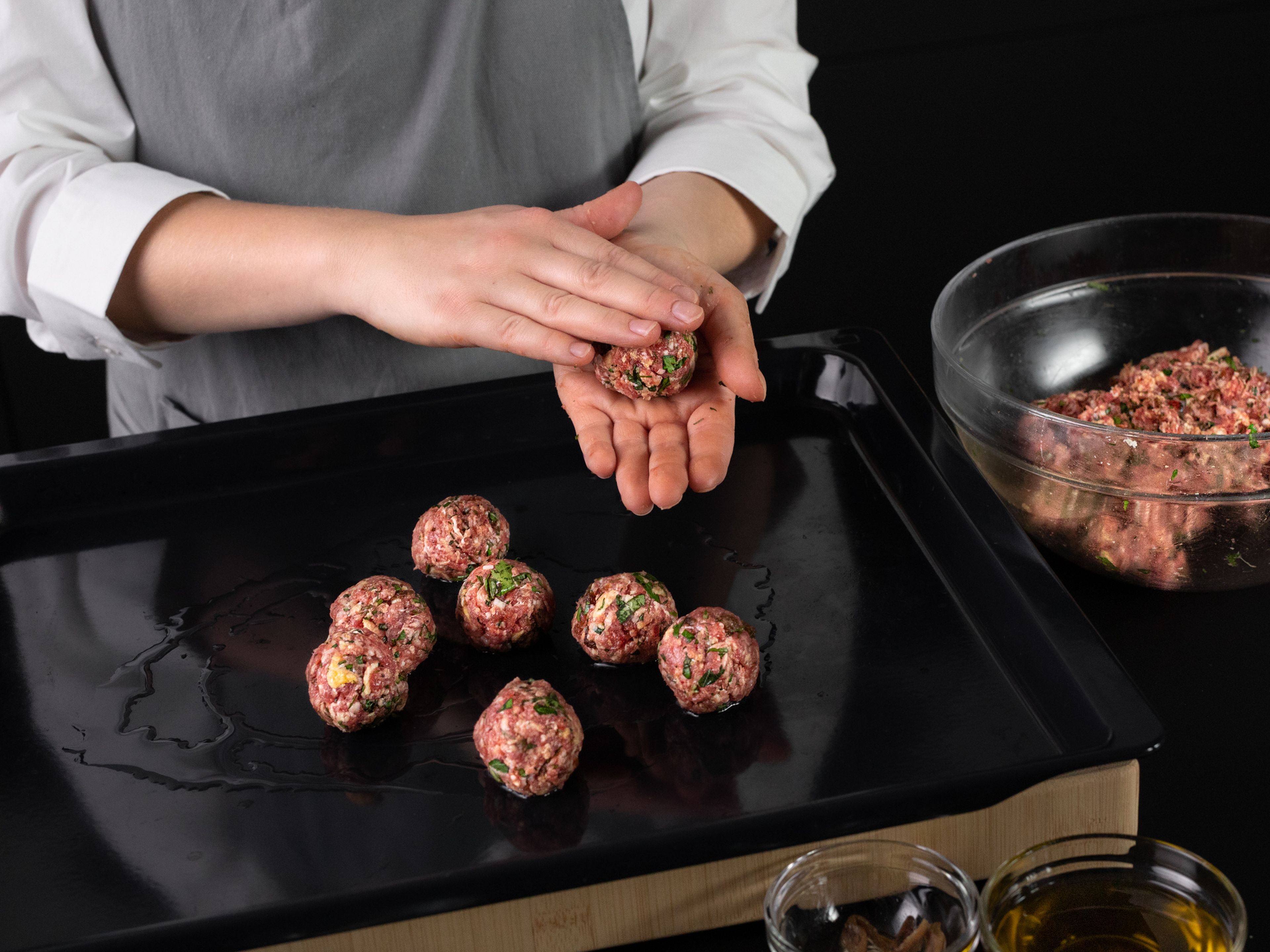 Add vegetable oil to a baking sheet, then use your palms to roll the meatball mixture into even balls about the size of a golf ball, placing them directly on the baking sheet when formed. Gently roll the meatballs to coat in oil, then transfer to oven and bake at 220°C/425°F for approx. 10 min.